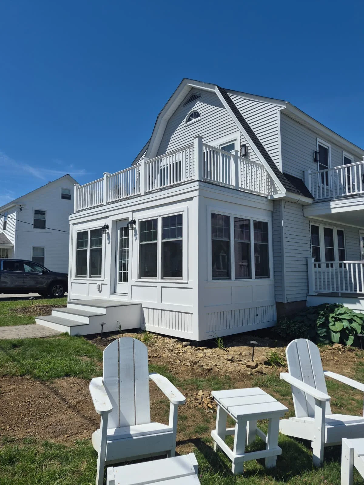 Finished water-side enclosed three-season porch with a master-bedroom deck above, York ME