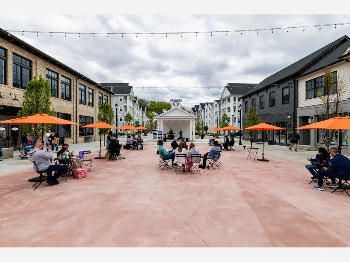 The new Piazza at Eastdale Village, with outdoor tables, orange umbrellas, and a central pavilion.