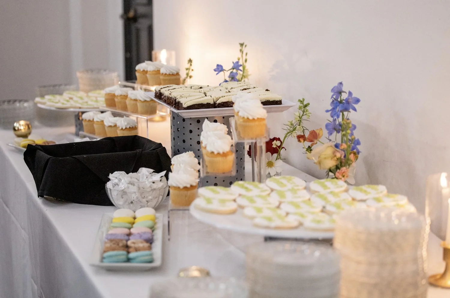 Dessert table styled with loose delphinium, cosmos and garden roses