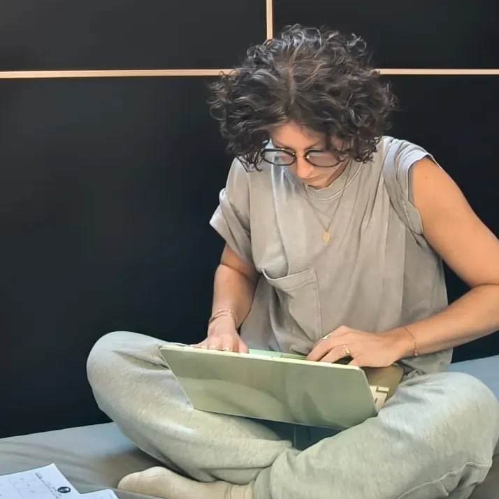 Fiorella al lavoro sul portatile, seduta sul letto