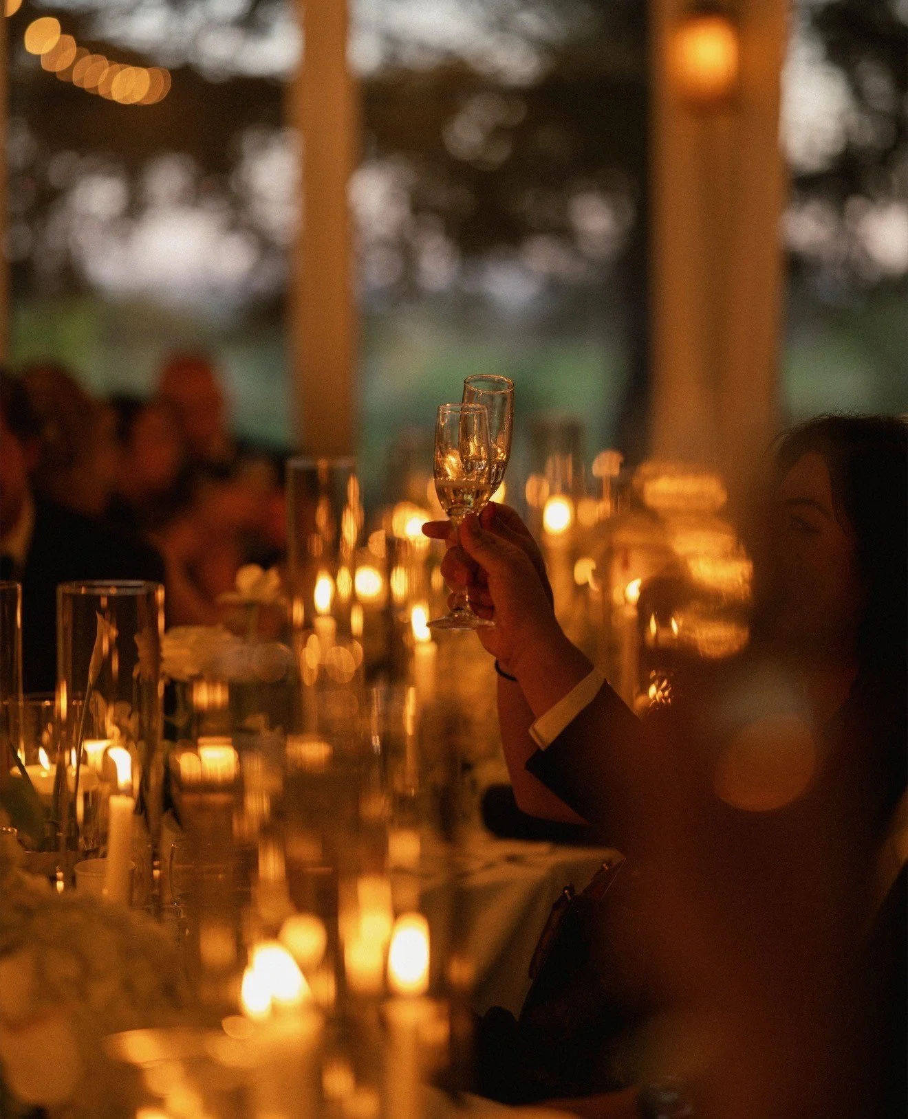 Candlelight glowing across a reception table