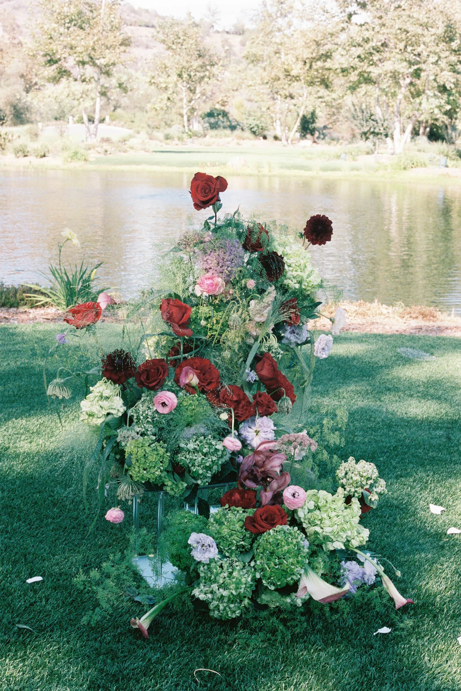 Burgundy and white ceremony flowers beside the water