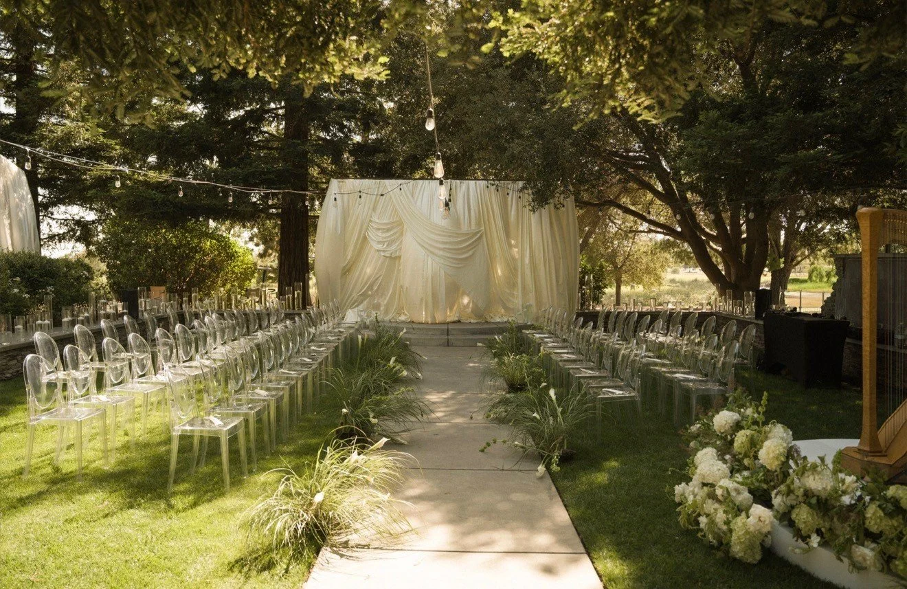 Garden ceremony aisle beneath string lights