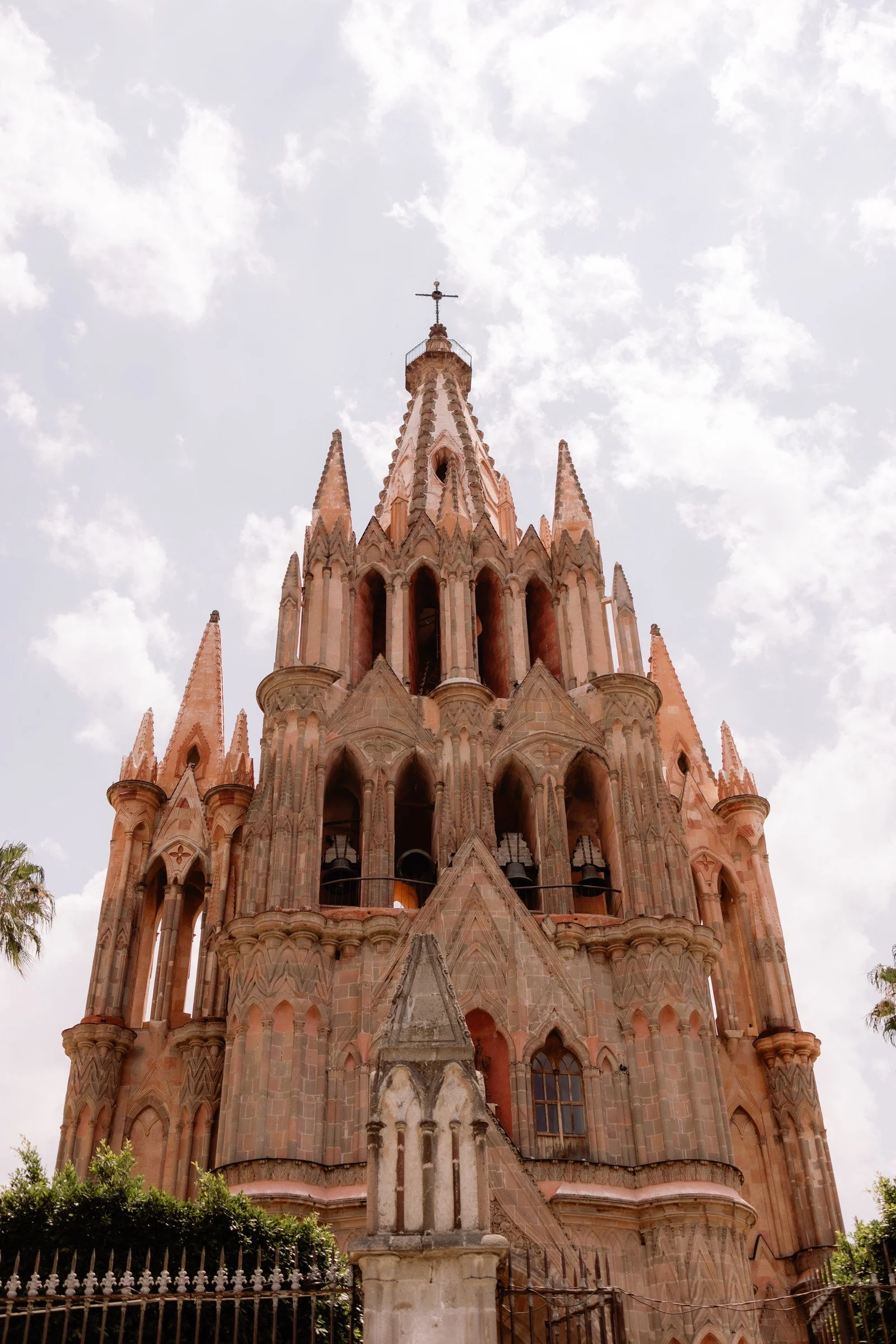 Pink stone church spires beneath a cloudy sky