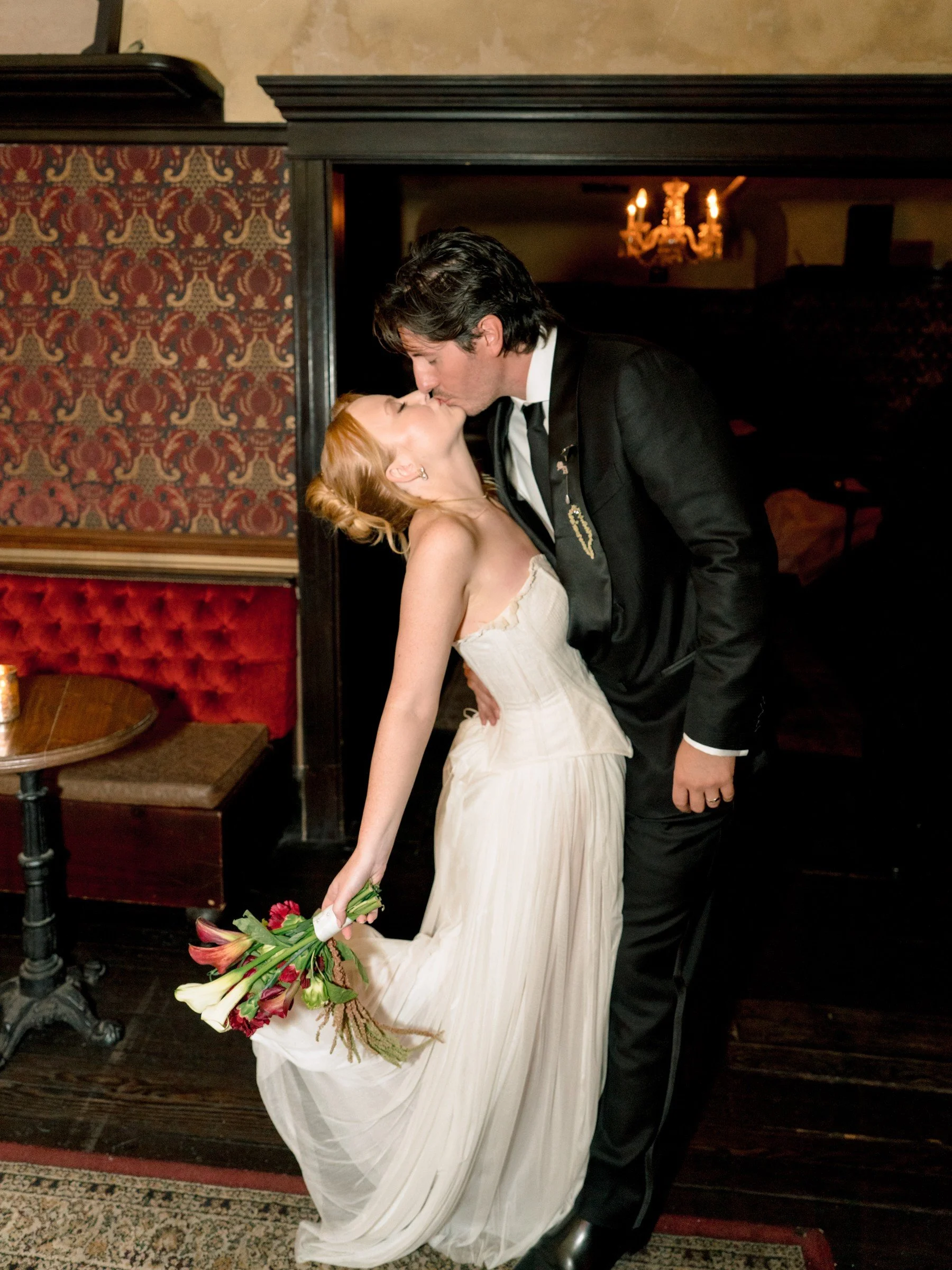Newlyweds kissing in a richly decorated room