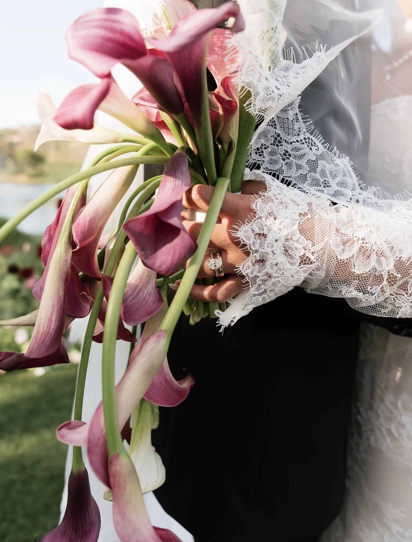 Burgundy and white calla lily bridal bouquet against delicate lace