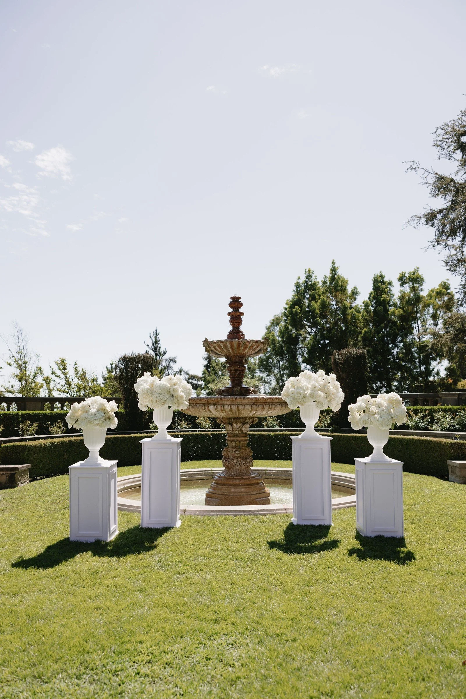 White floral urns around a garden fountain