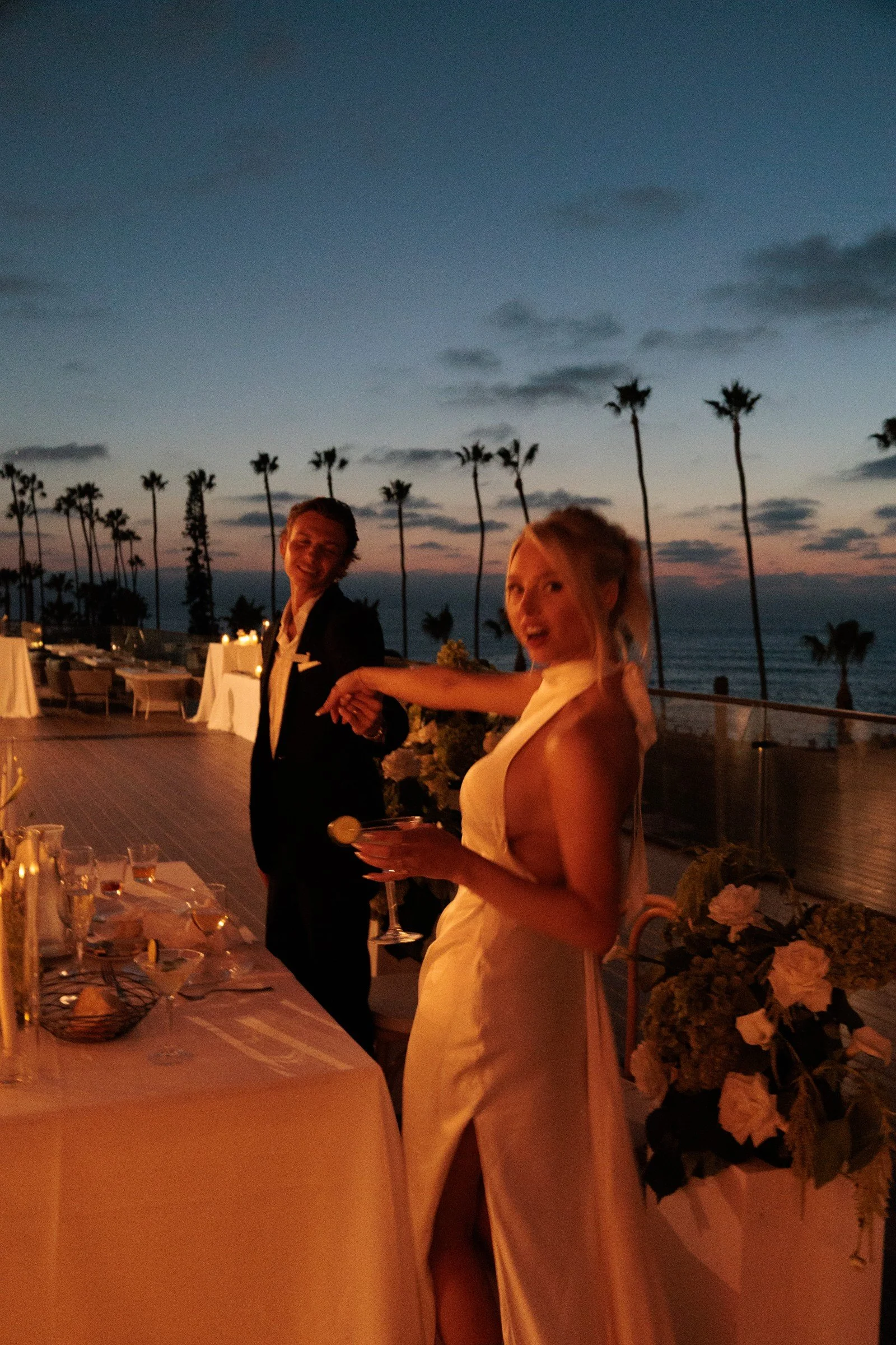 Bride raising a glass beside the candlelit reception