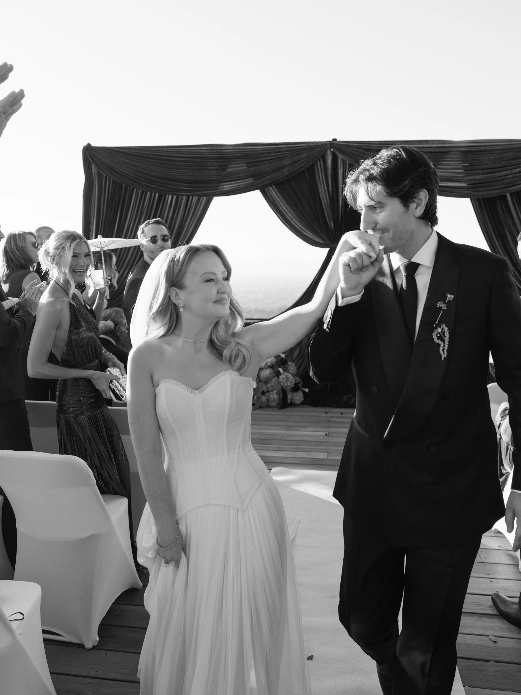 Newlyweds celebrating beneath dark ceremony draping