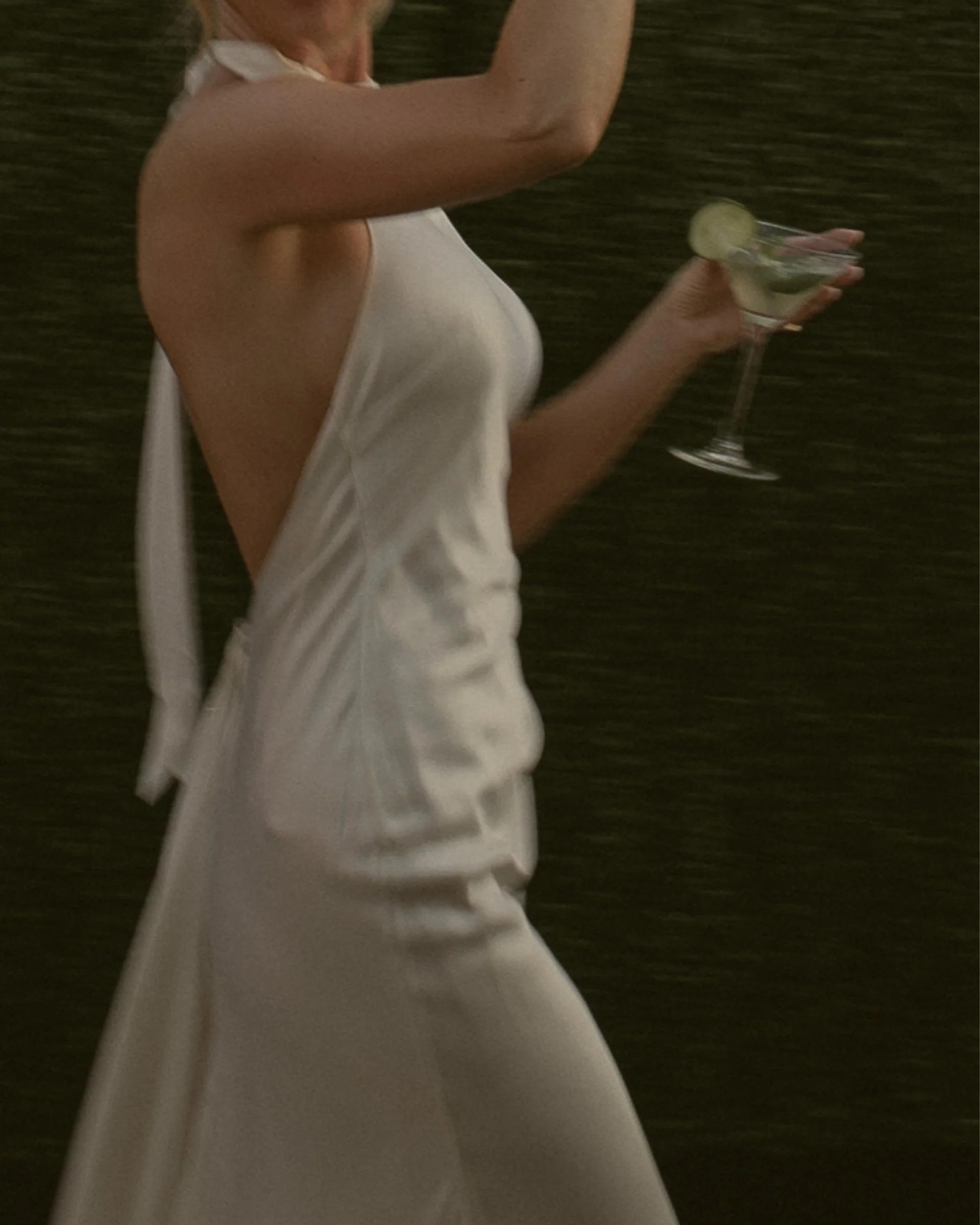 Bride holding a cocktail in a white satin dress
