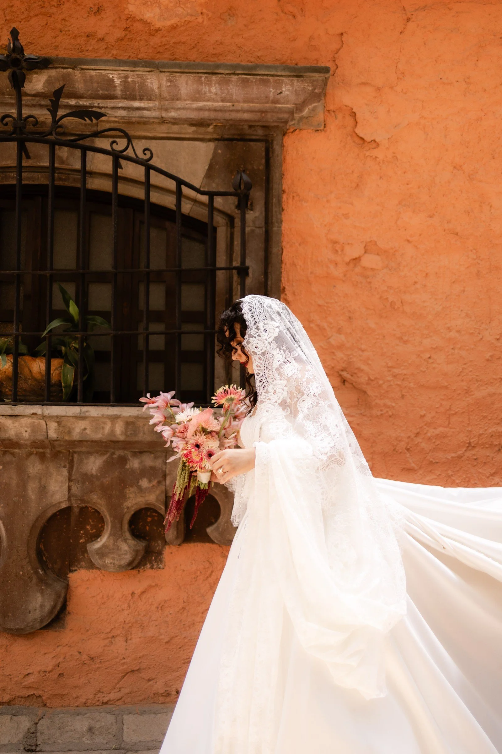 Bride beside a terracotta wall in Mexico