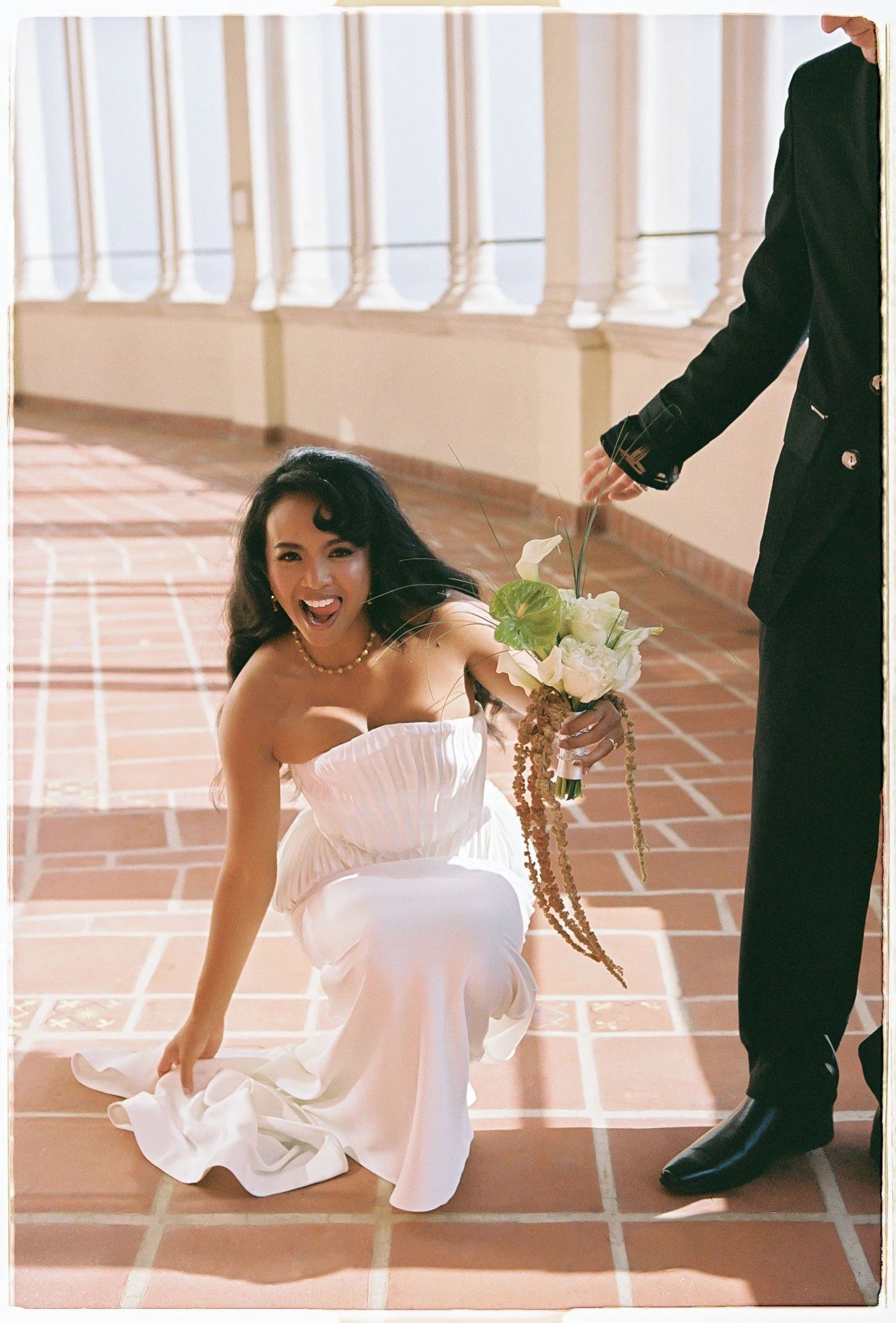 Bride descending tiled stairs in a white wedding dress