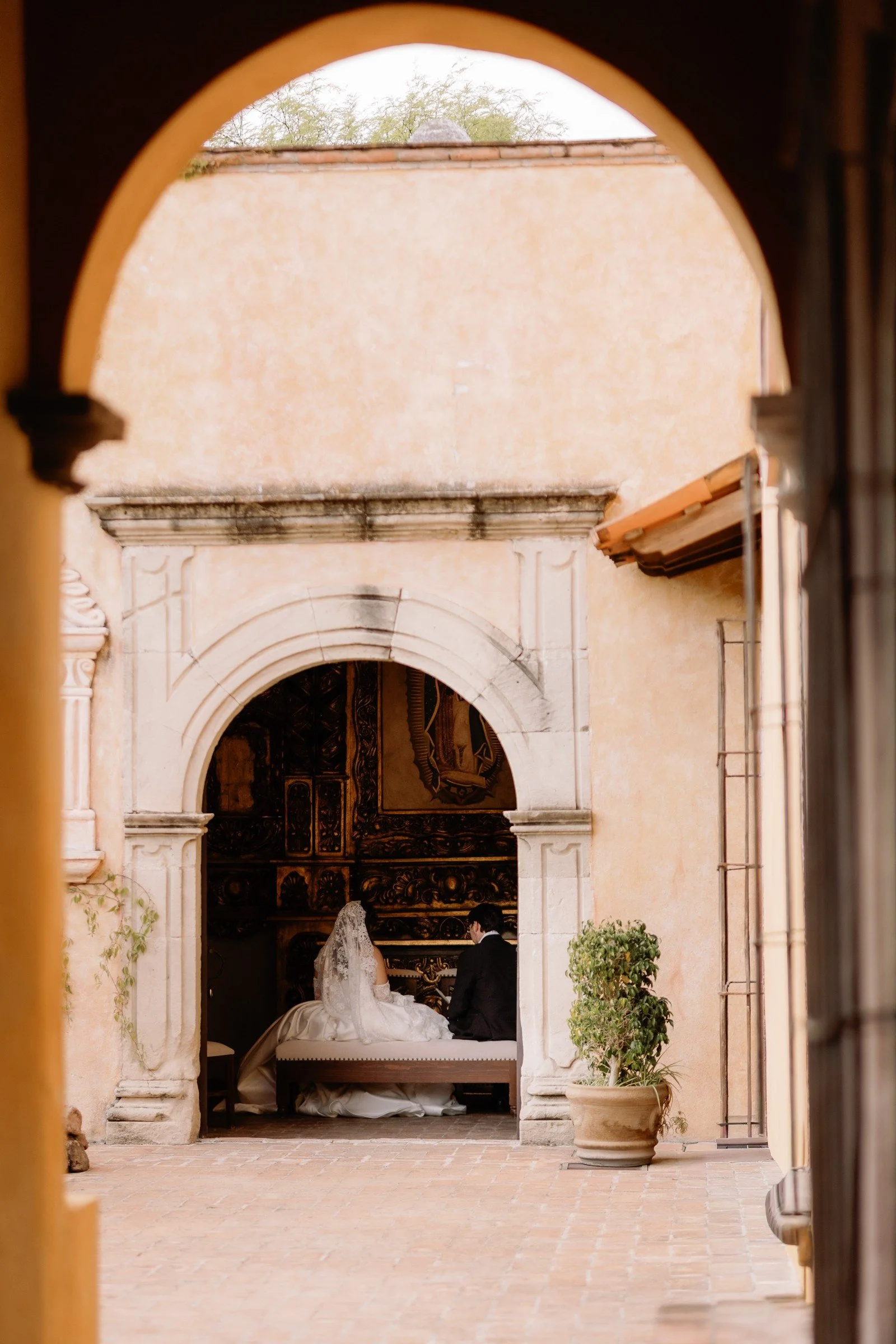 Bride framed by an ornate courtyard arch