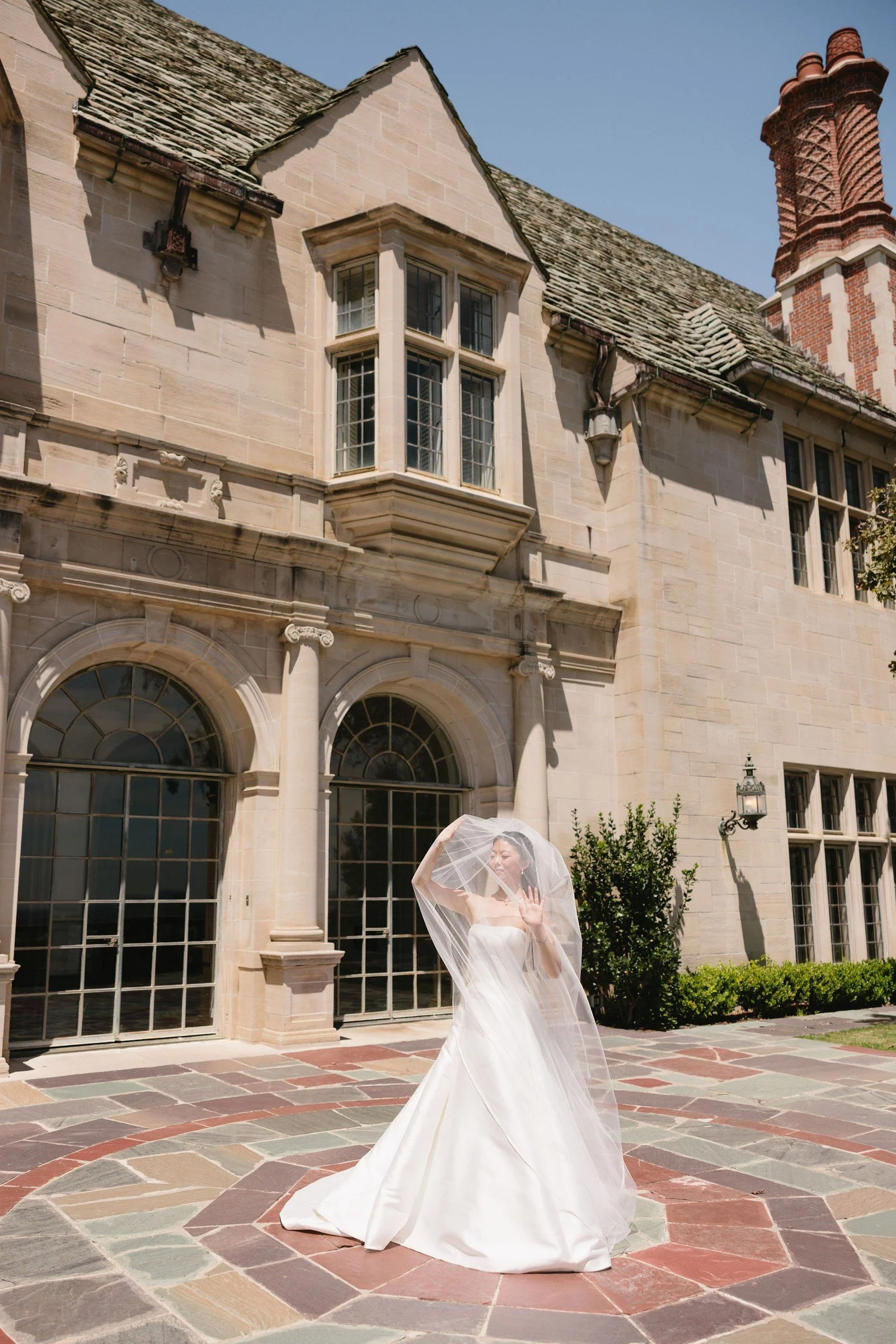 Bride standing in a stone courtyard