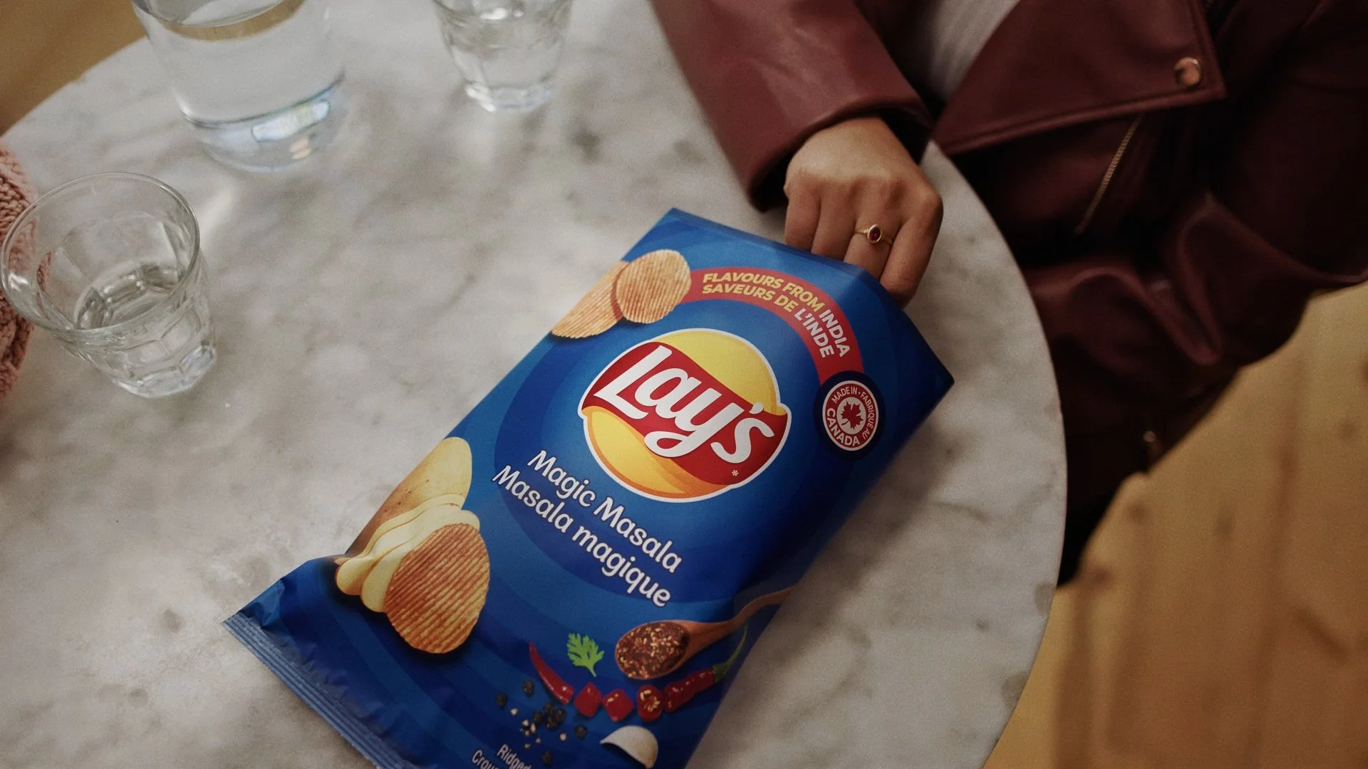A woman grabs chips from a bag in a Lays Chips commercial video