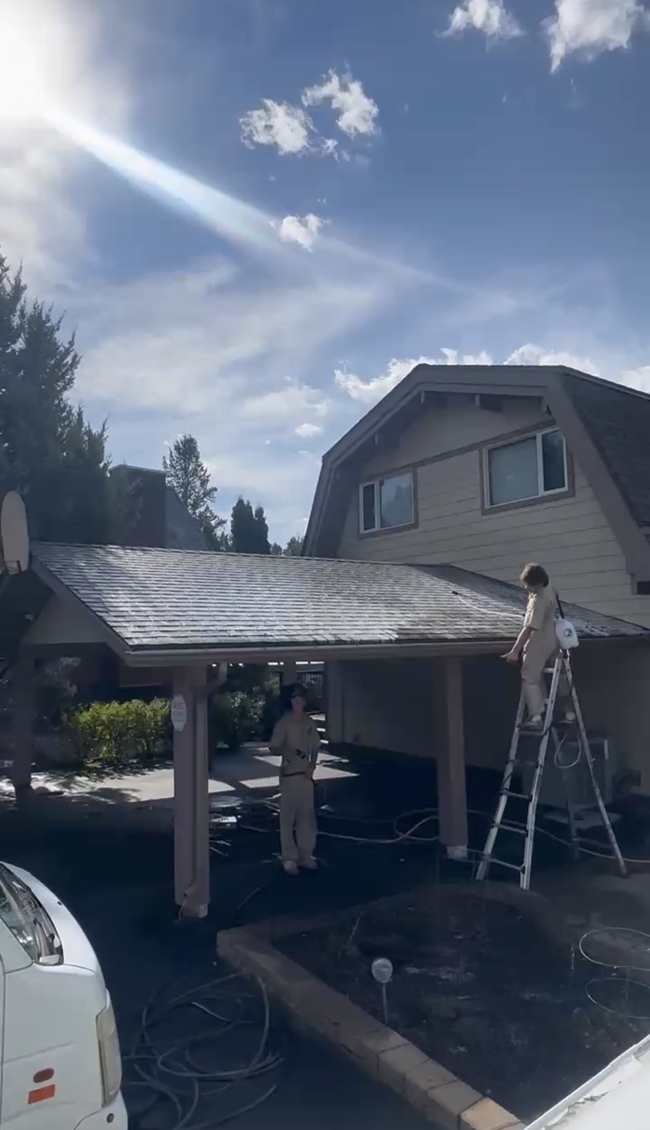 Valley Shiners crew applying a low-pressure roof moss treatment to asphalt shingles in Windermere, British Columbia