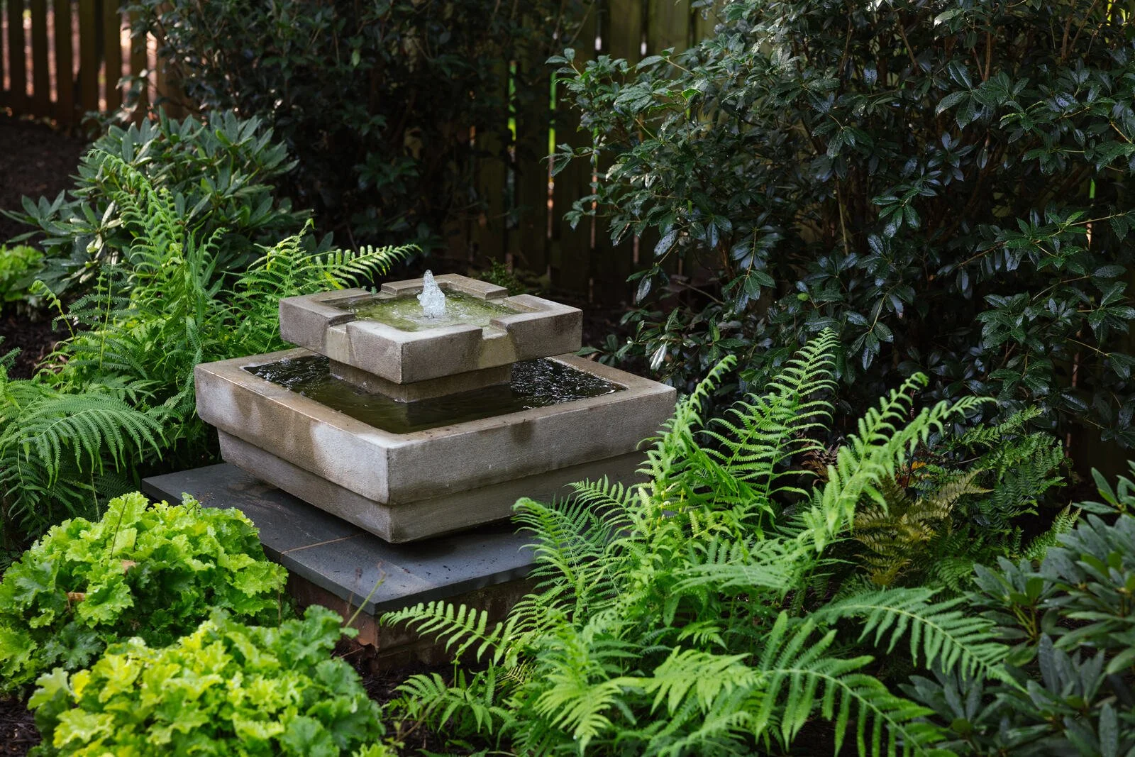 Rear gathering garden with stepping stones and fire seating beneath mature trees