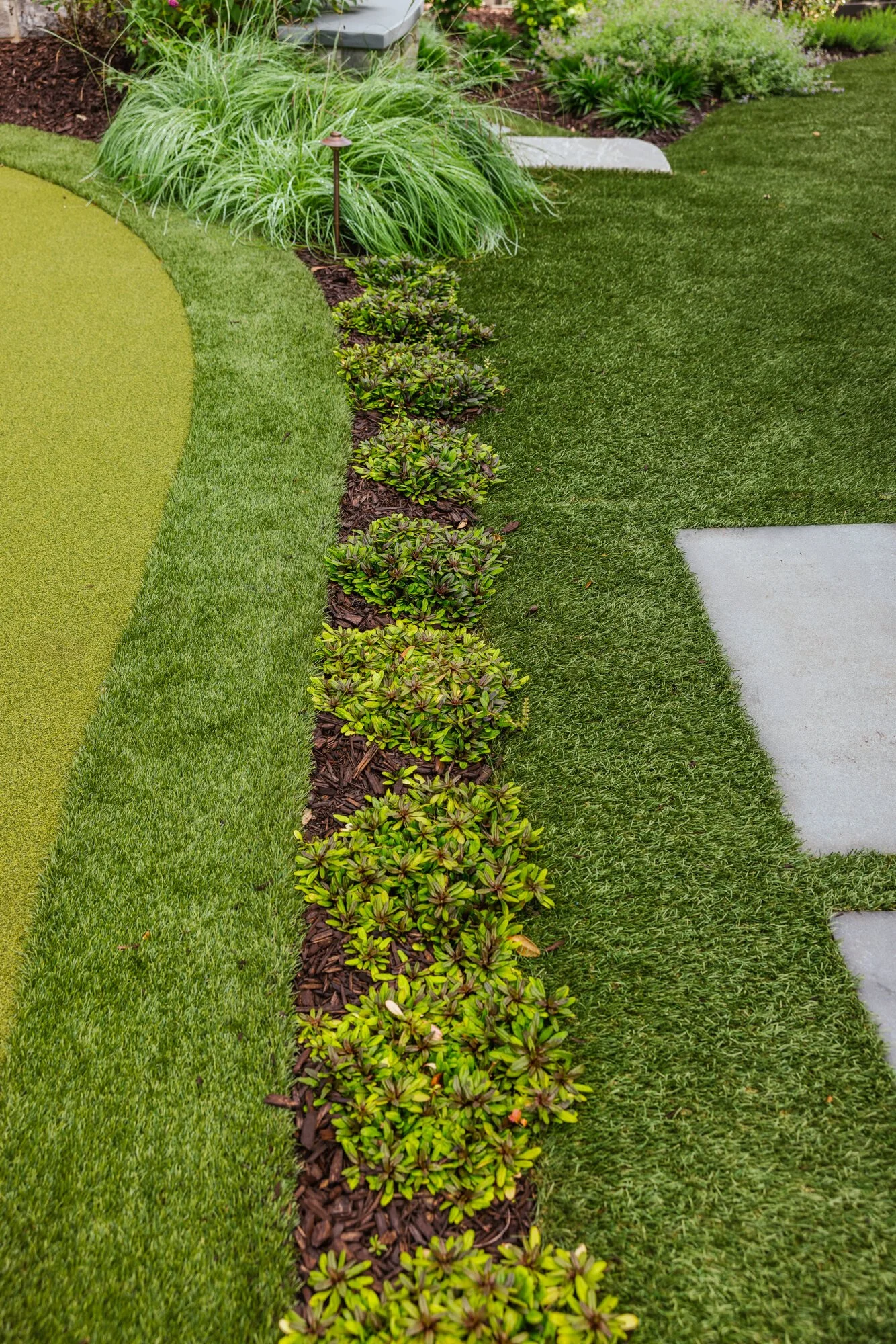 Planting edge and bluestone step beside the putting green