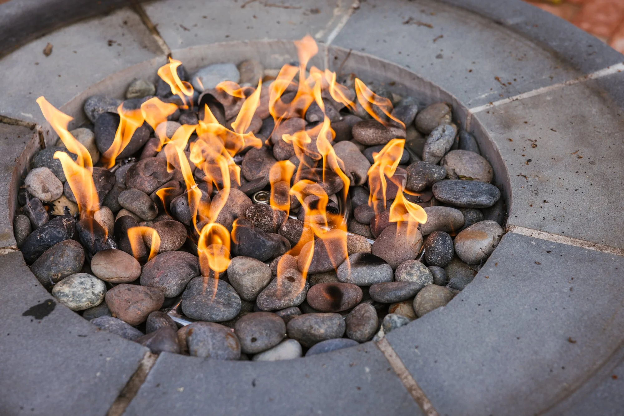 Gas flames within the round stone fire feature