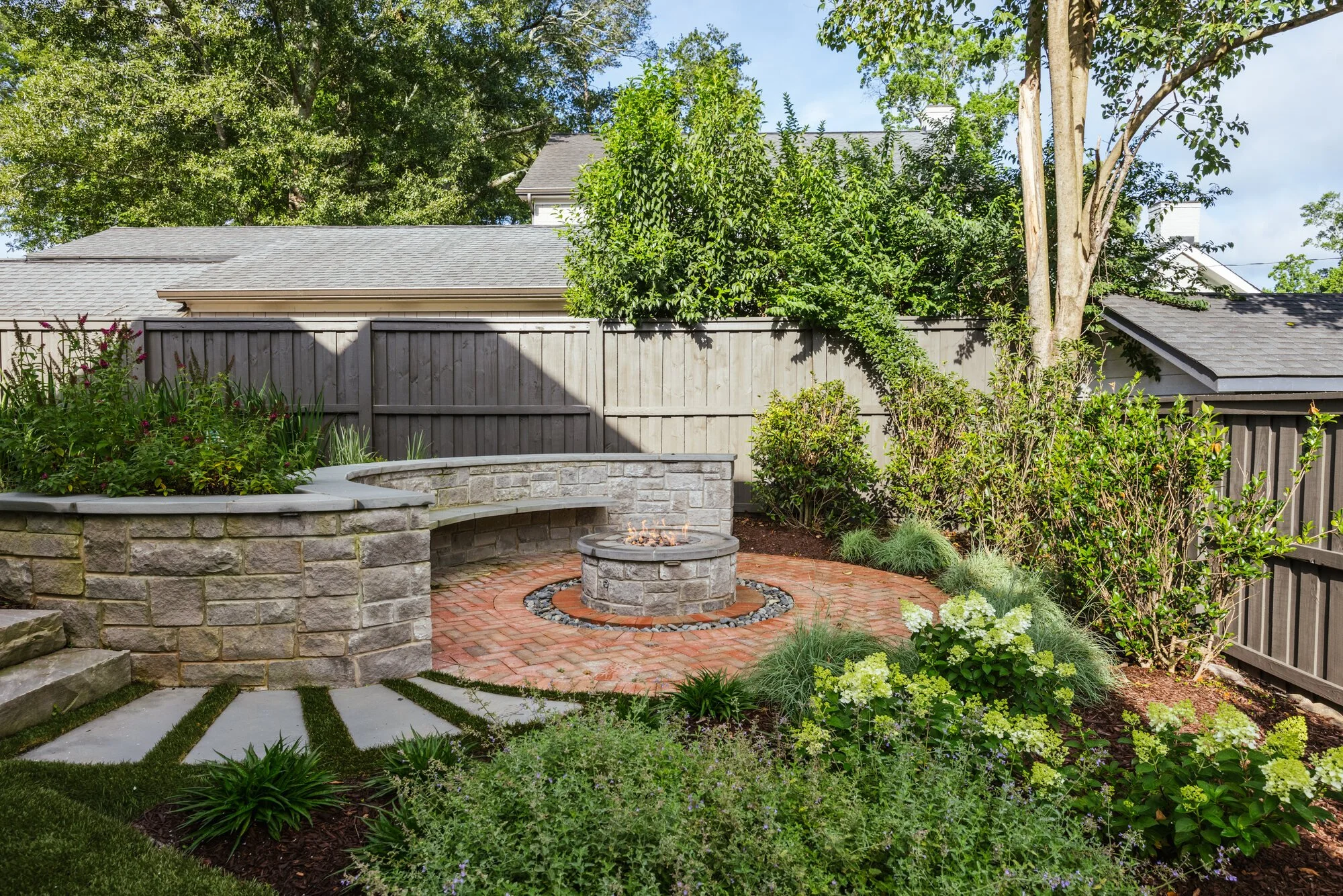 Curved stone seat wall surrounding the brick fire terrace
