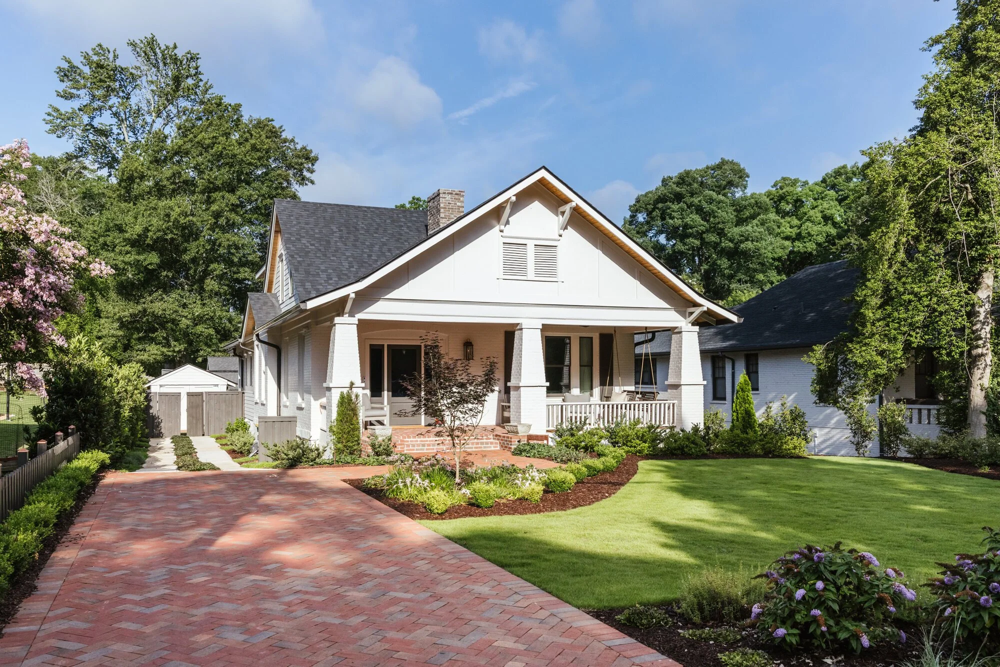 White bungalow and brick motor court at the Cherokee residence in Five Points, Athens, Georgia