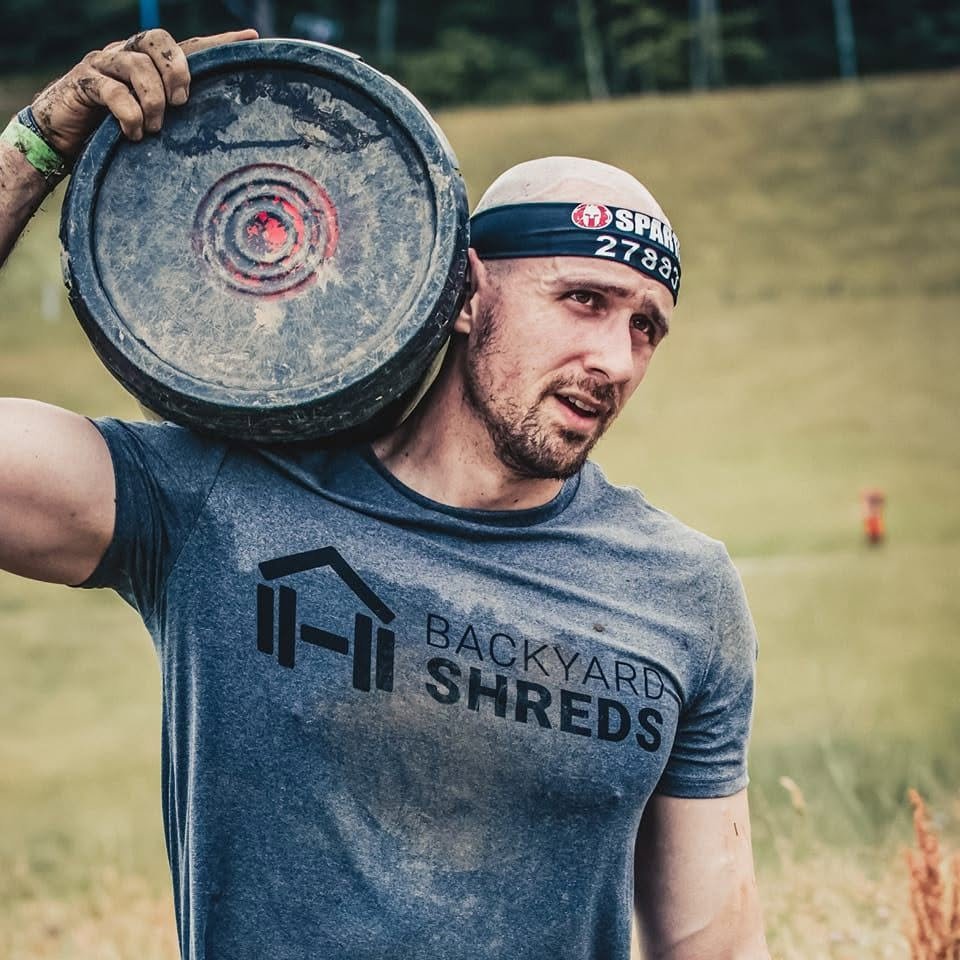 Cody carrying a weighted bucket during a Spartan race
