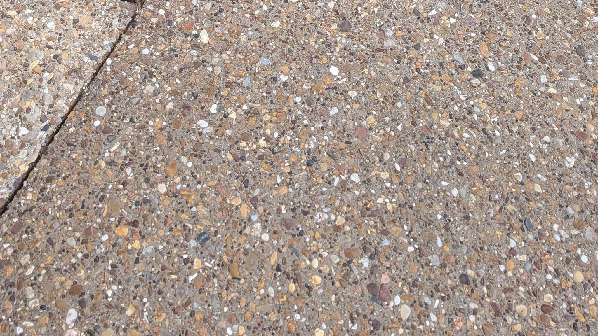 Close-up of exposed aggregate driveway with polished pebbles and cement matrix