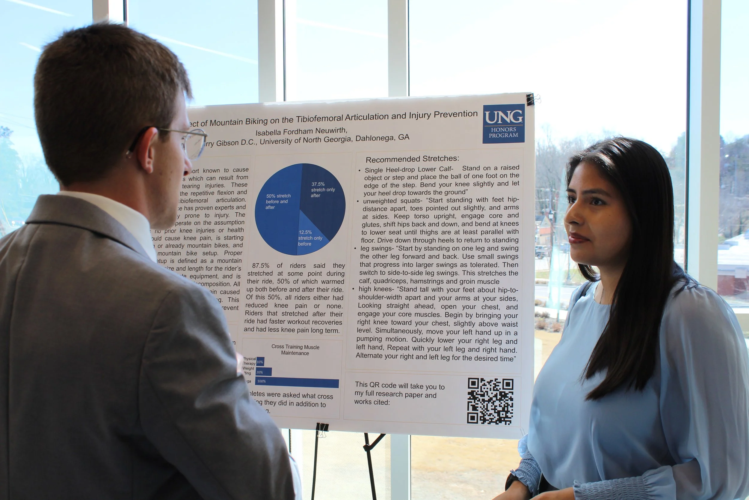 A woman presents a poster to a man in a suit.