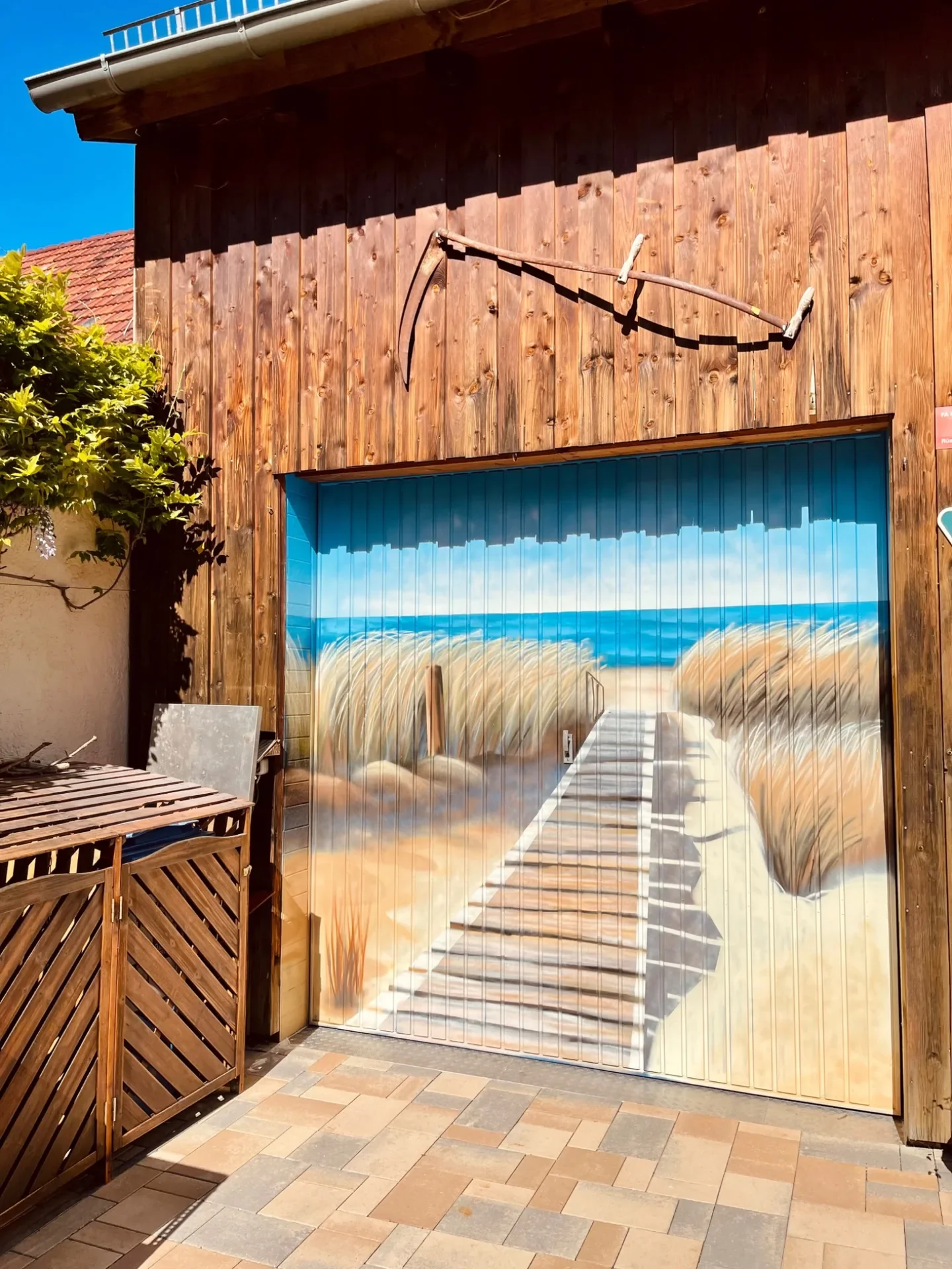 Garagentor mit Illusionsmalerei eines Holzstegs durch Dünen zum Meer