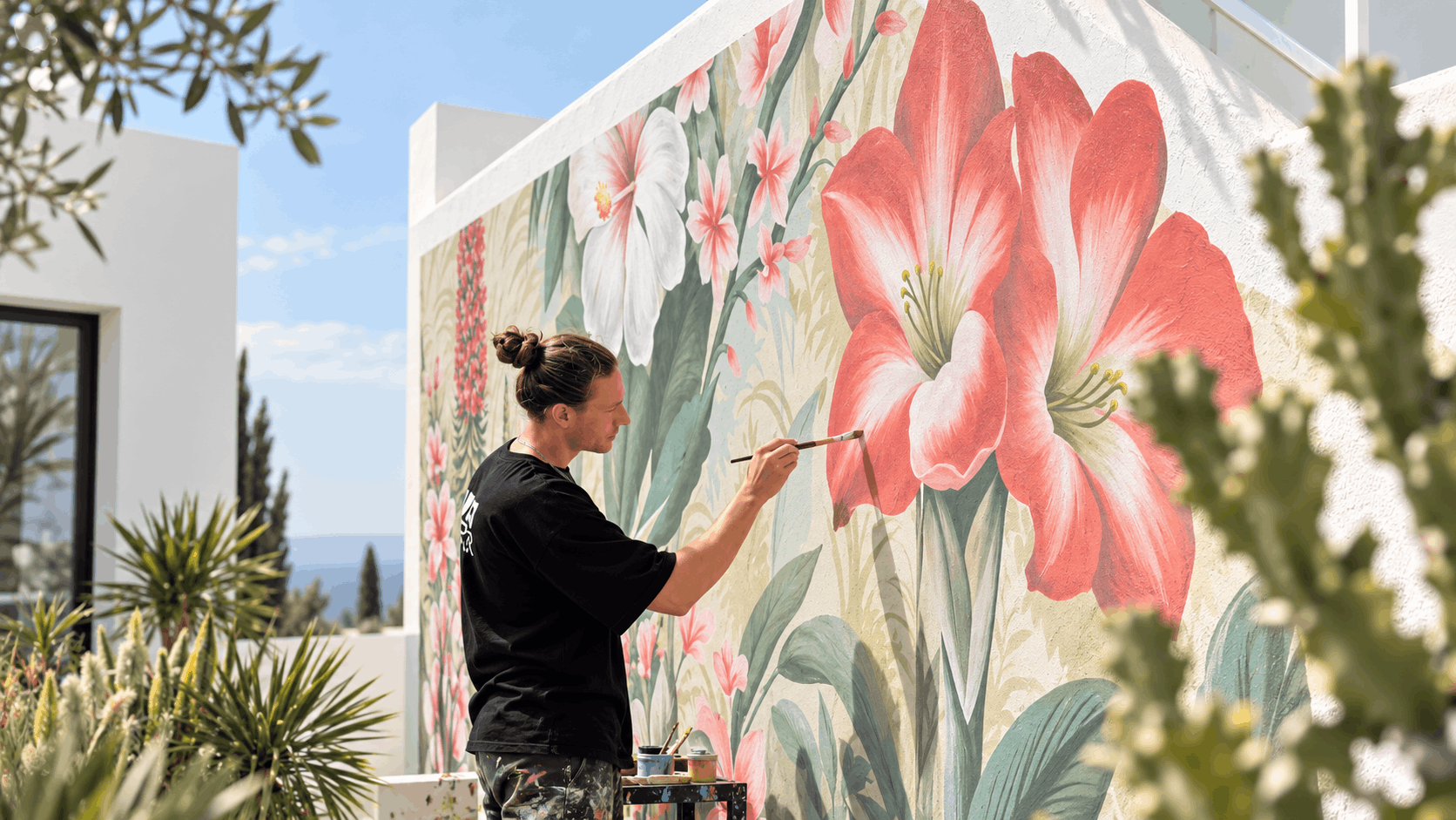Künstler Florian Erb beim Malen einer großformatigen floralen Wandgestaltung auf Teneriffa