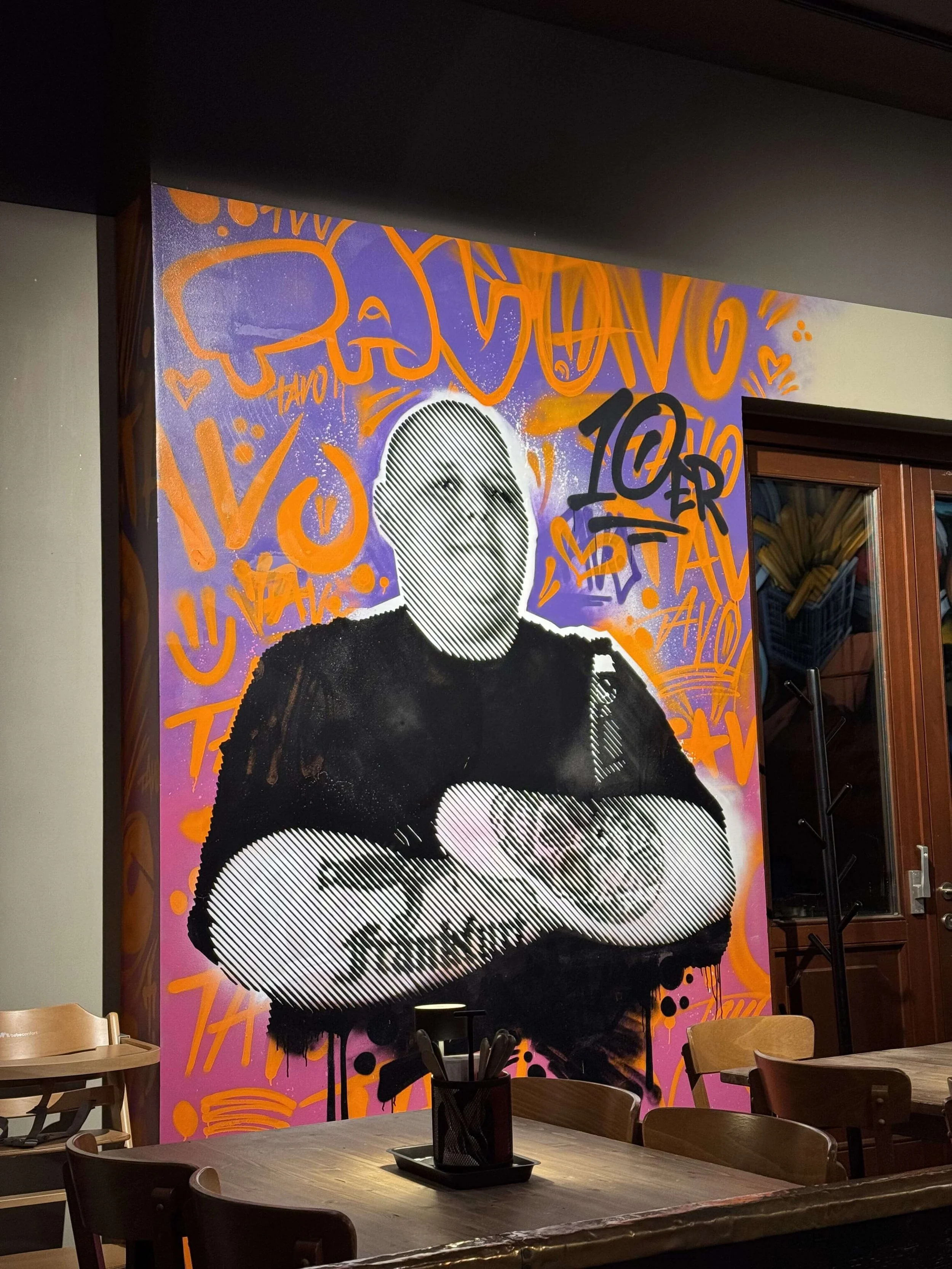 Figurative Wandgestaltung mit Portrait und grafischen Details in einem Restaurant