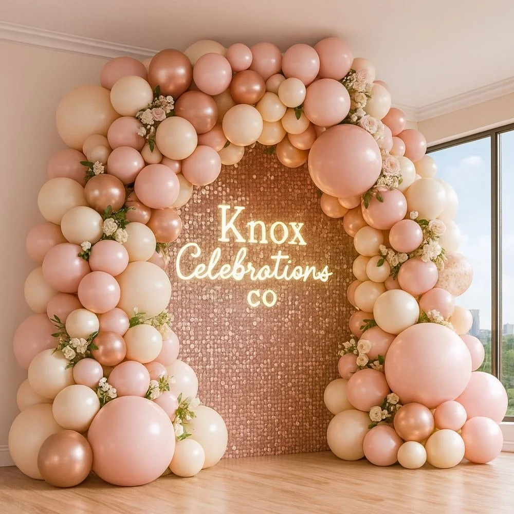 Blush and ivory balloon installation with an illuminated Knox Celebrations sign