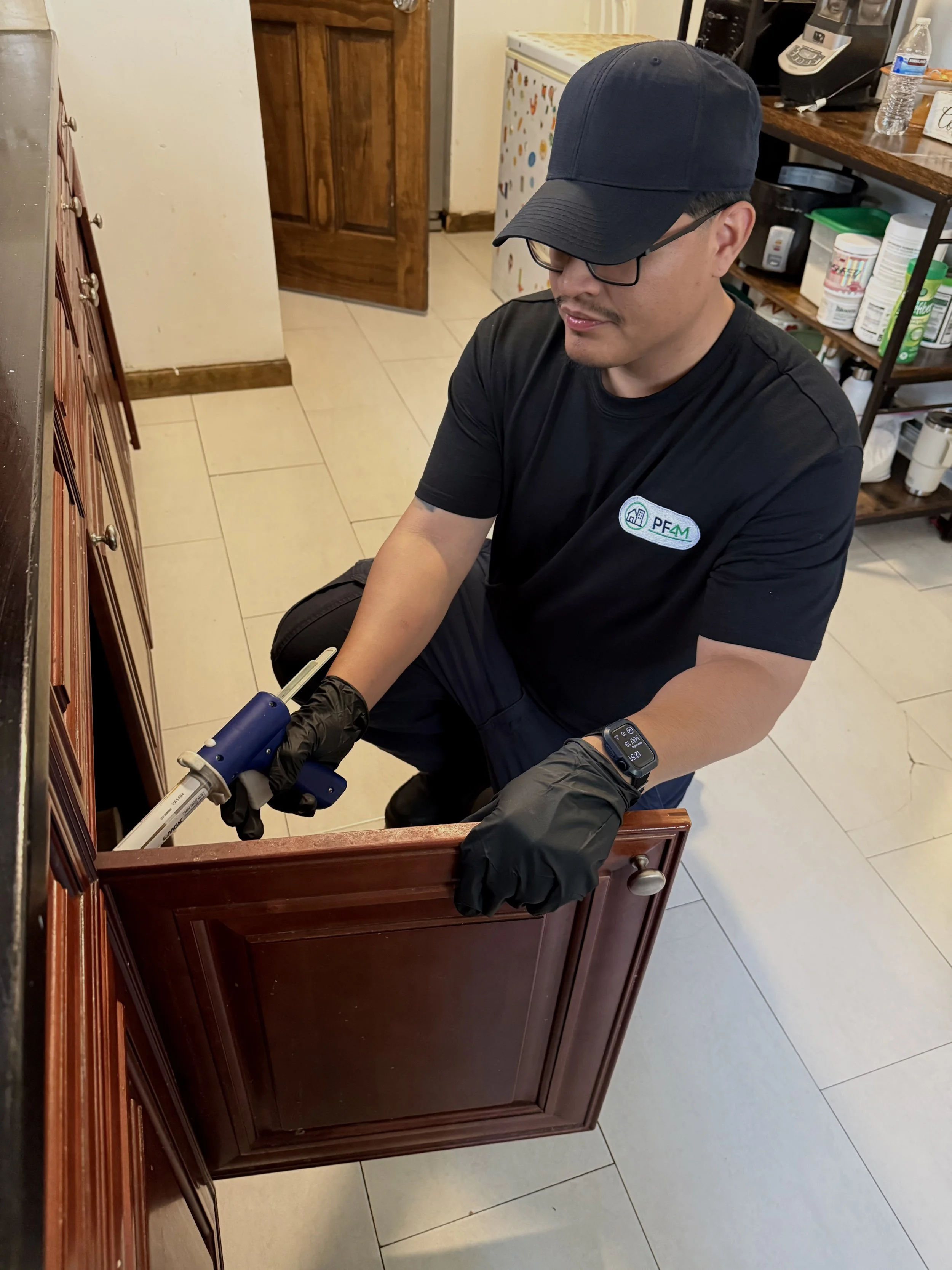 PestFree4Me technician applying pest-control bait indoors