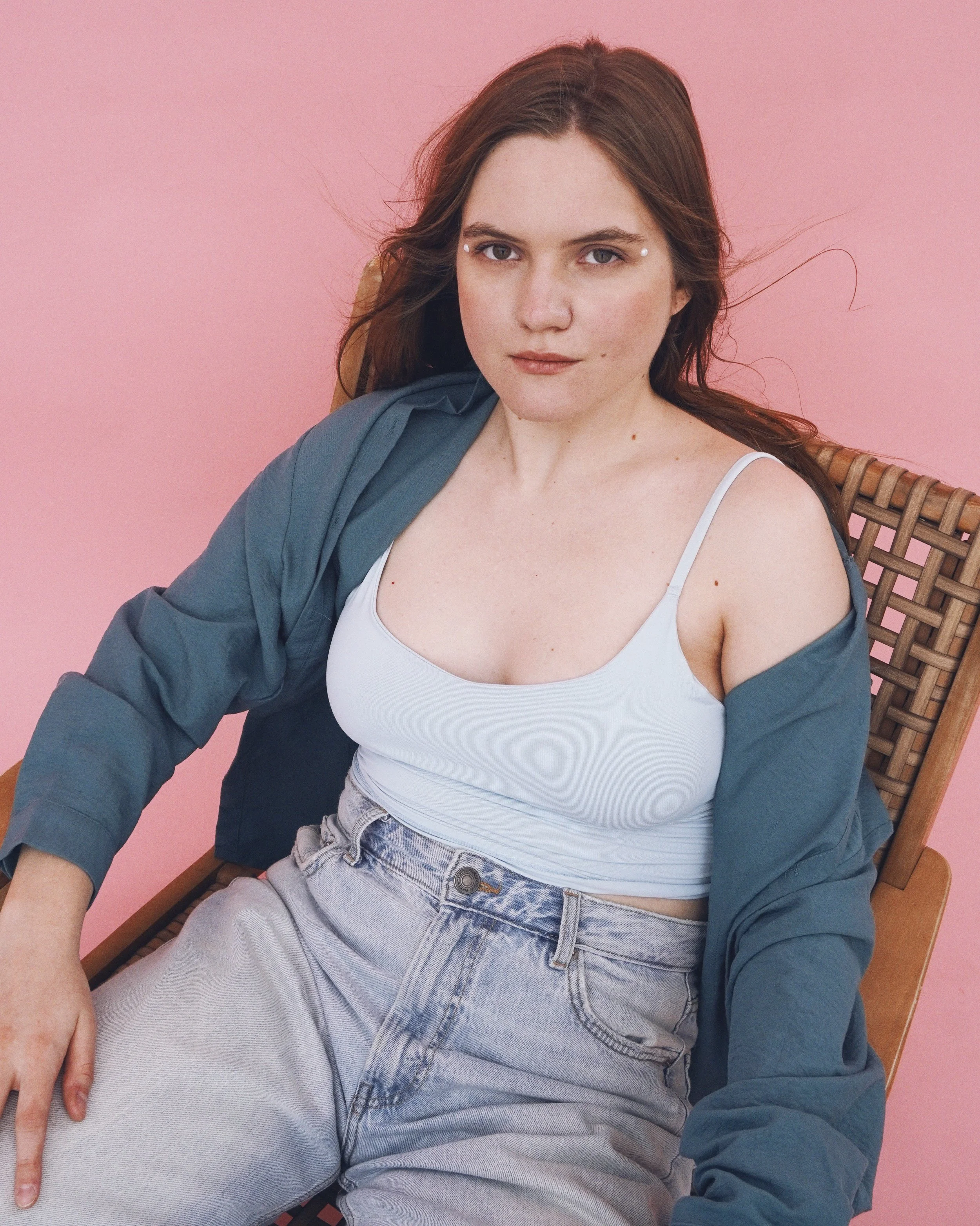 Soffel seated in a chair against a pink background