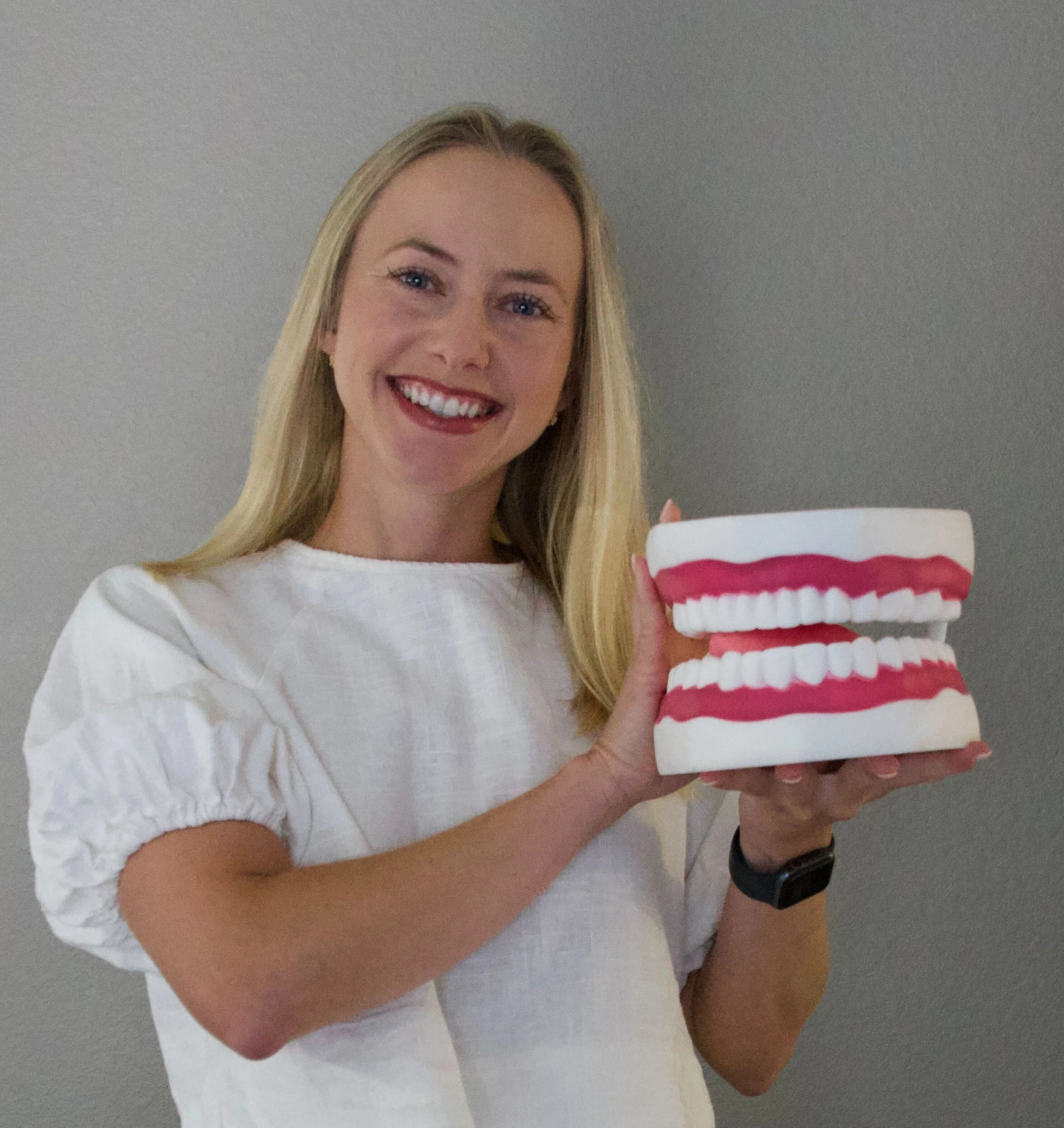 Speech therapist Ms. Lydia holding a dental model