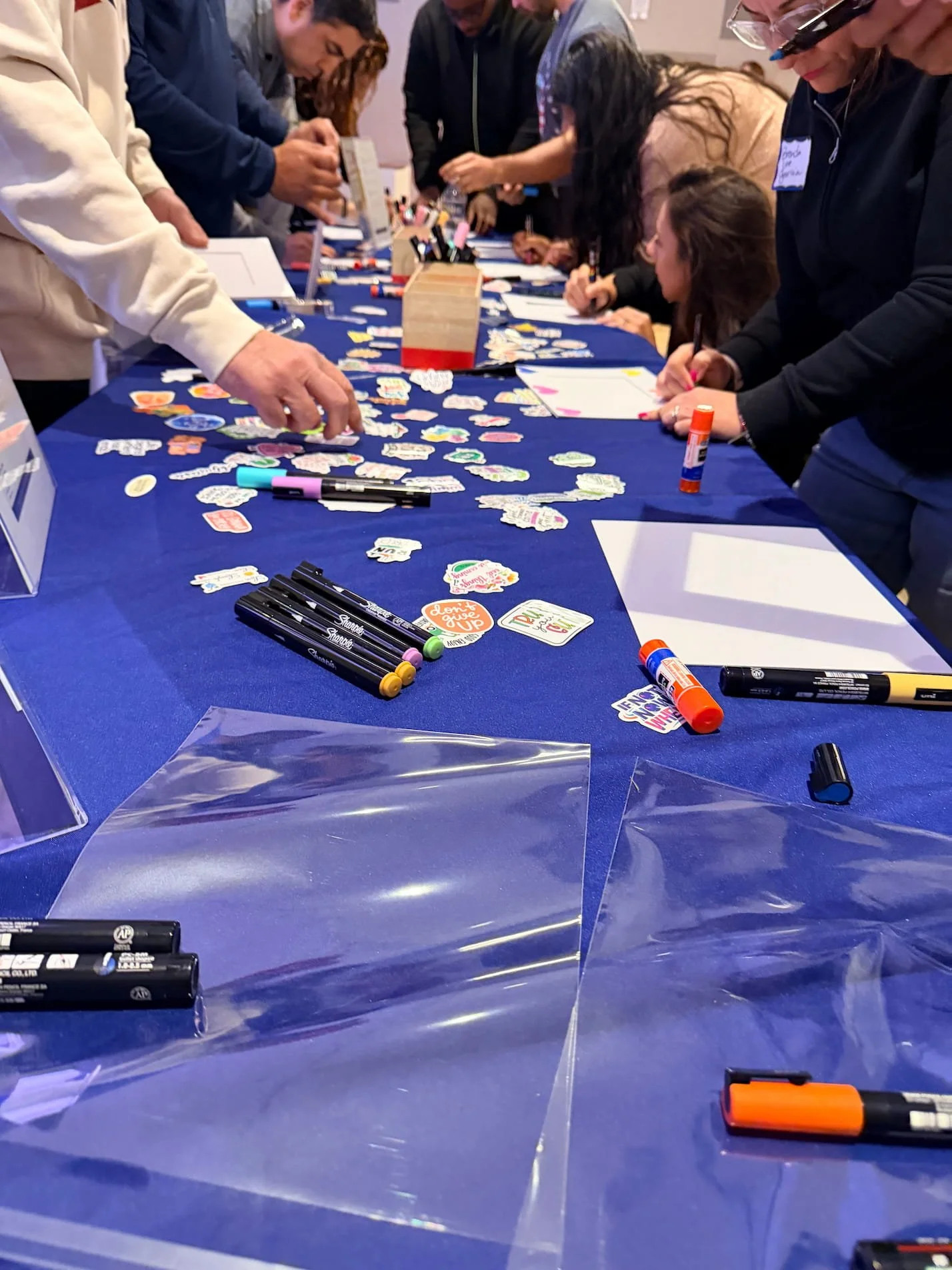 People painting wooden frames together at a community healing gathering