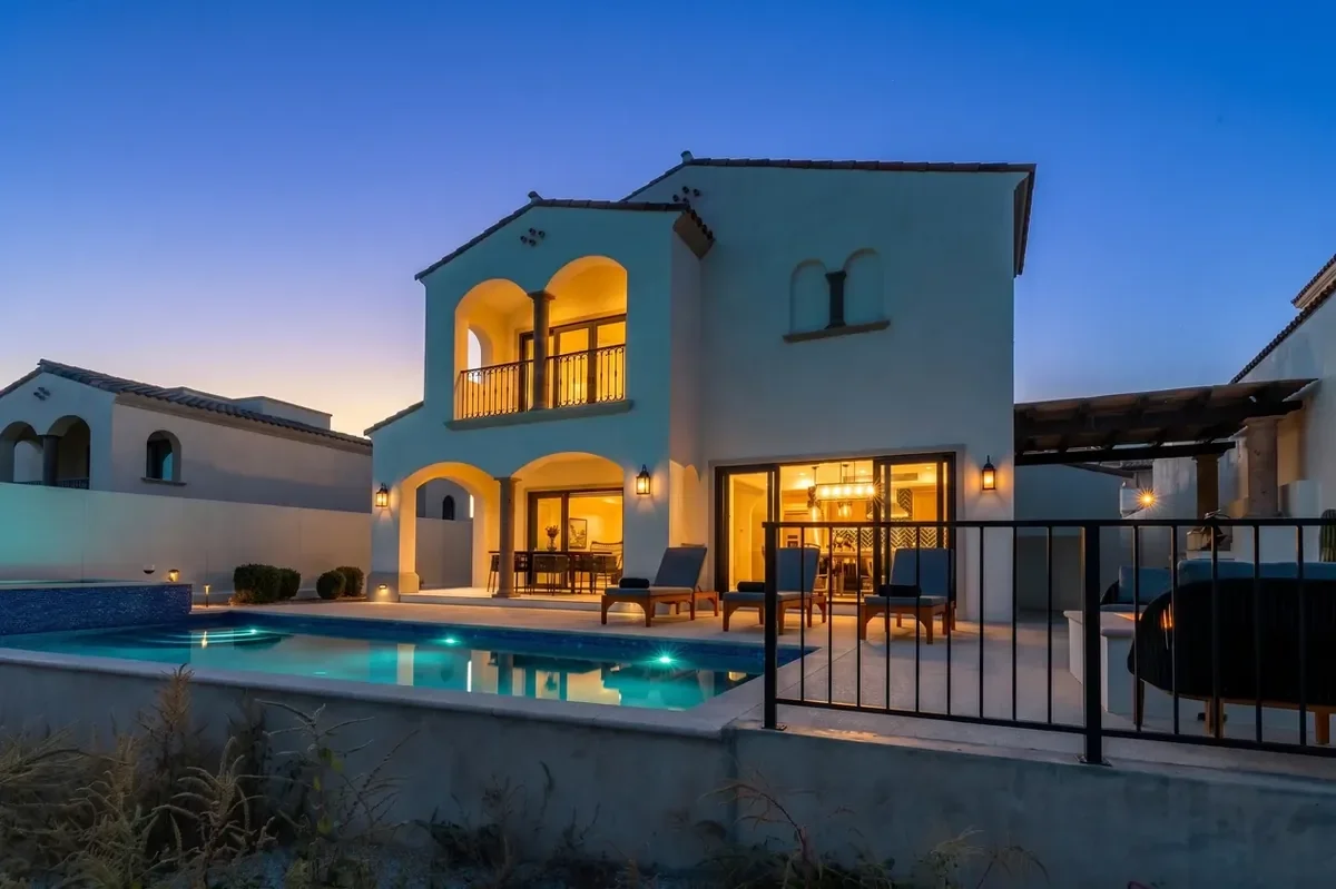 Two-story exterior facade of Rancho San Lucas Villa 10 at blue hour with pool and jacuzzi.