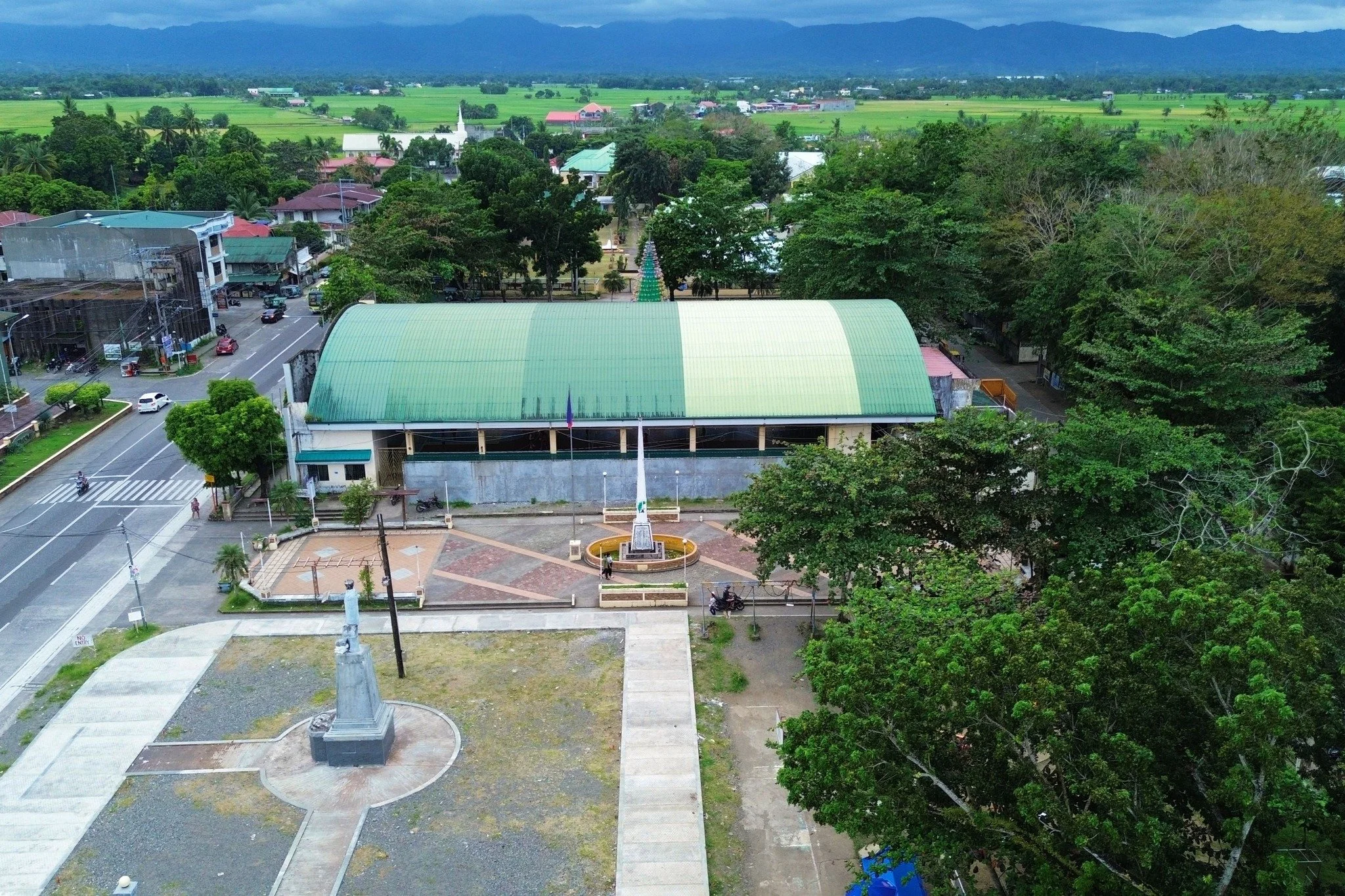Numancia town center with its civic hall and plaza, rice fields and distant mountains behind