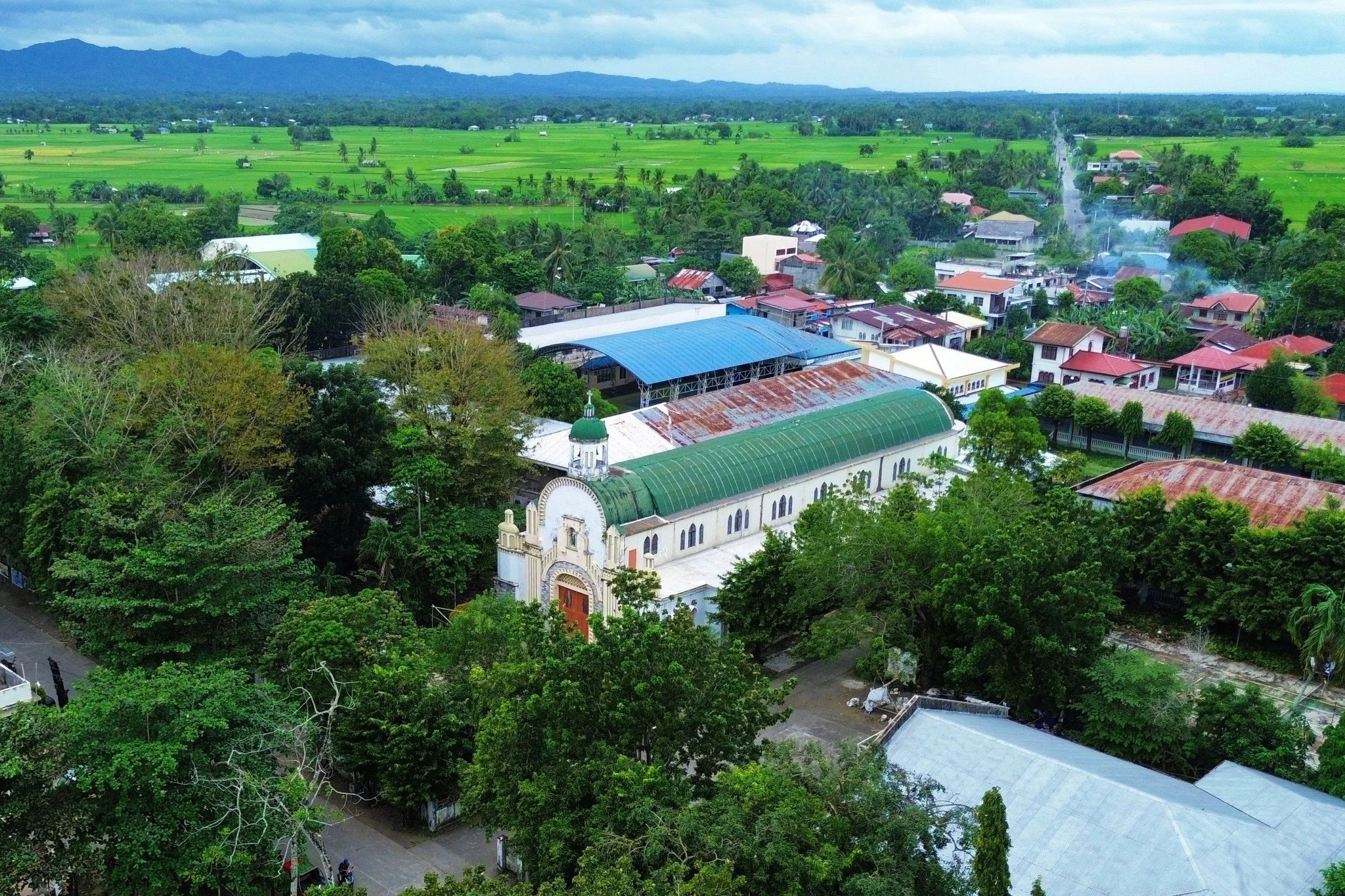 Aerial view of Numancia, Aklan—the parish church surrounded by trees, with rice fields stretching to the hills beyond