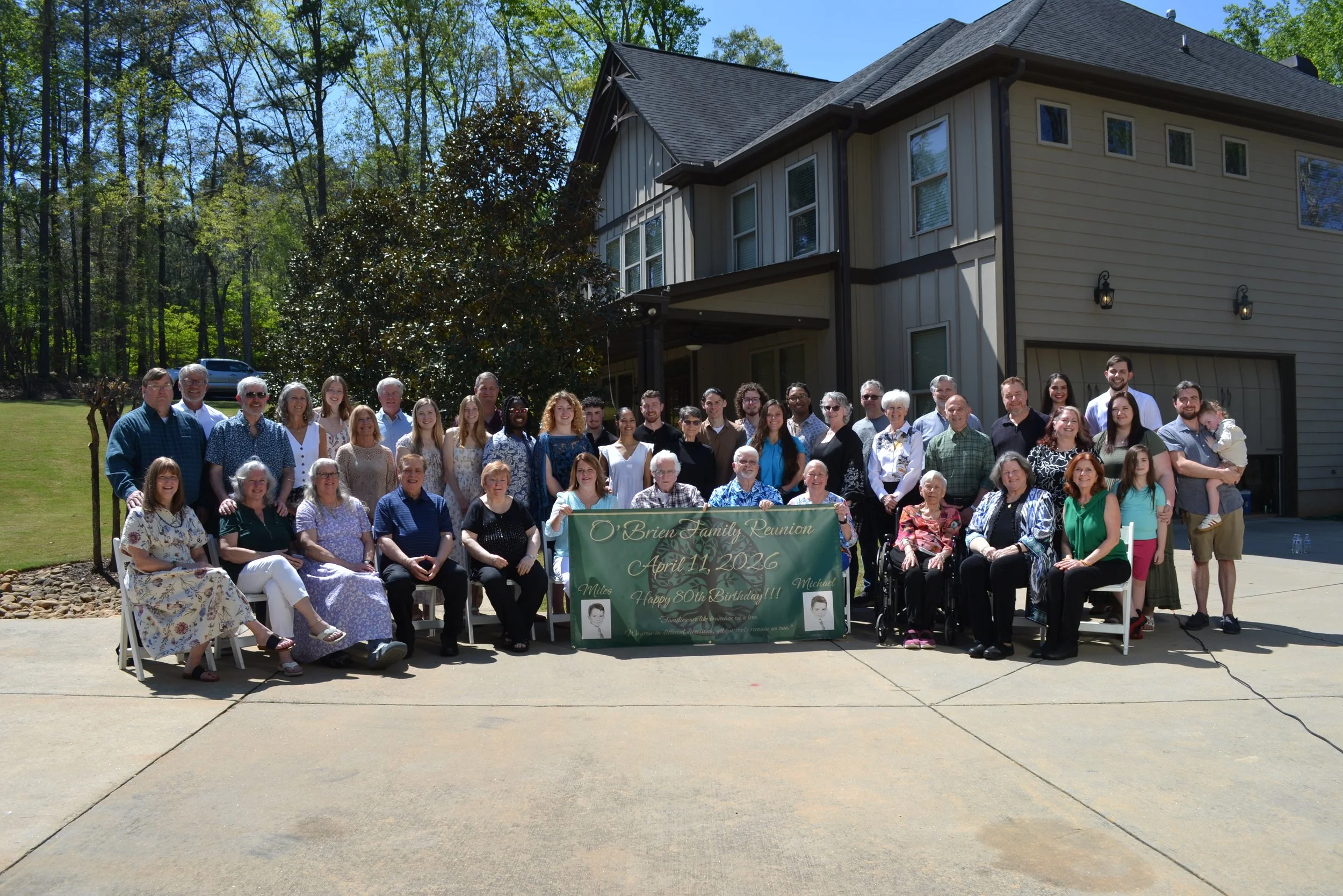 The full O'Brien family gathered with the green reunion banner displaying childhood portraits of Miles and Michael