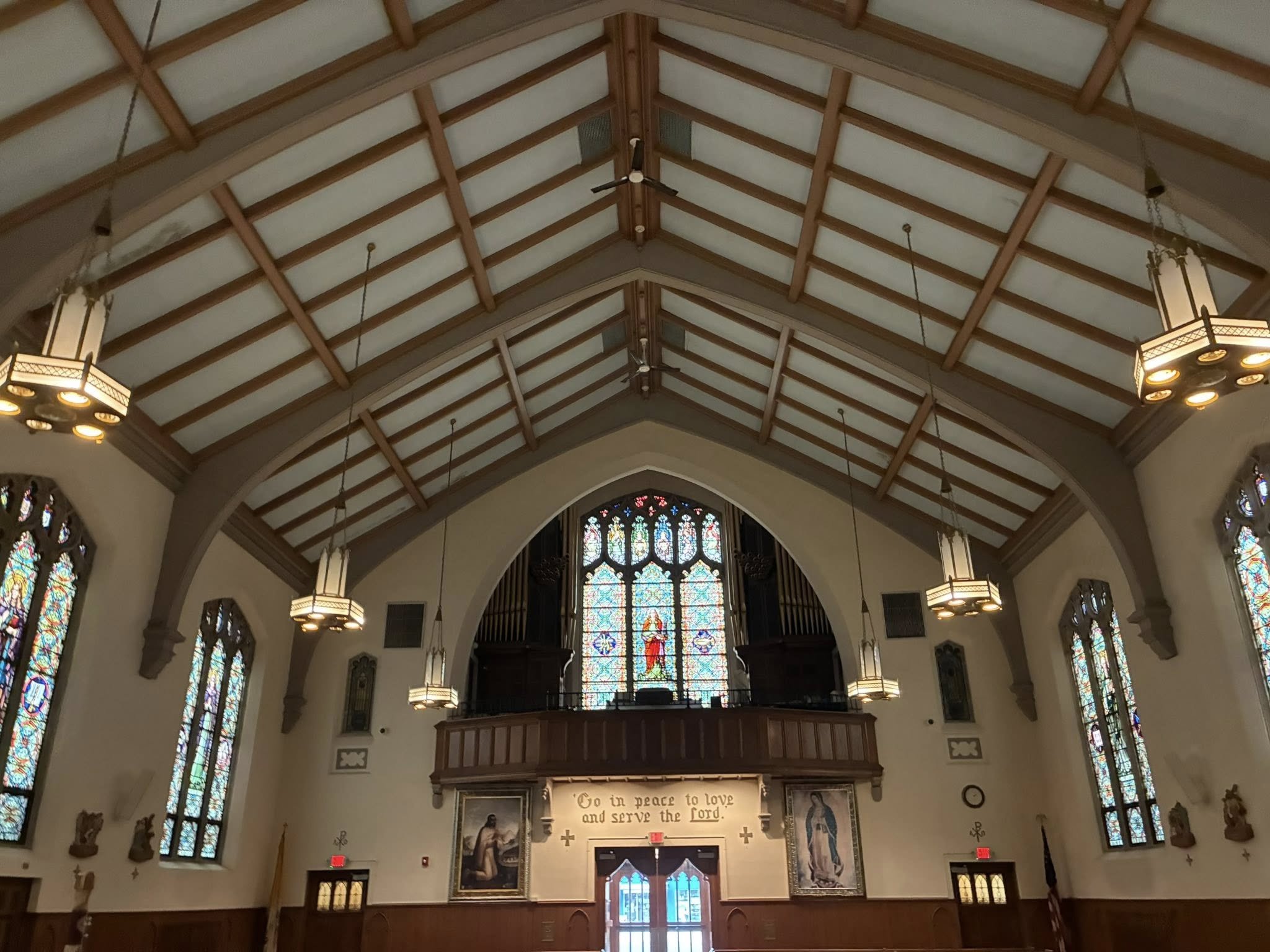 Interior of St. Aloysius Church showing choir loft, stained glass, and inscription