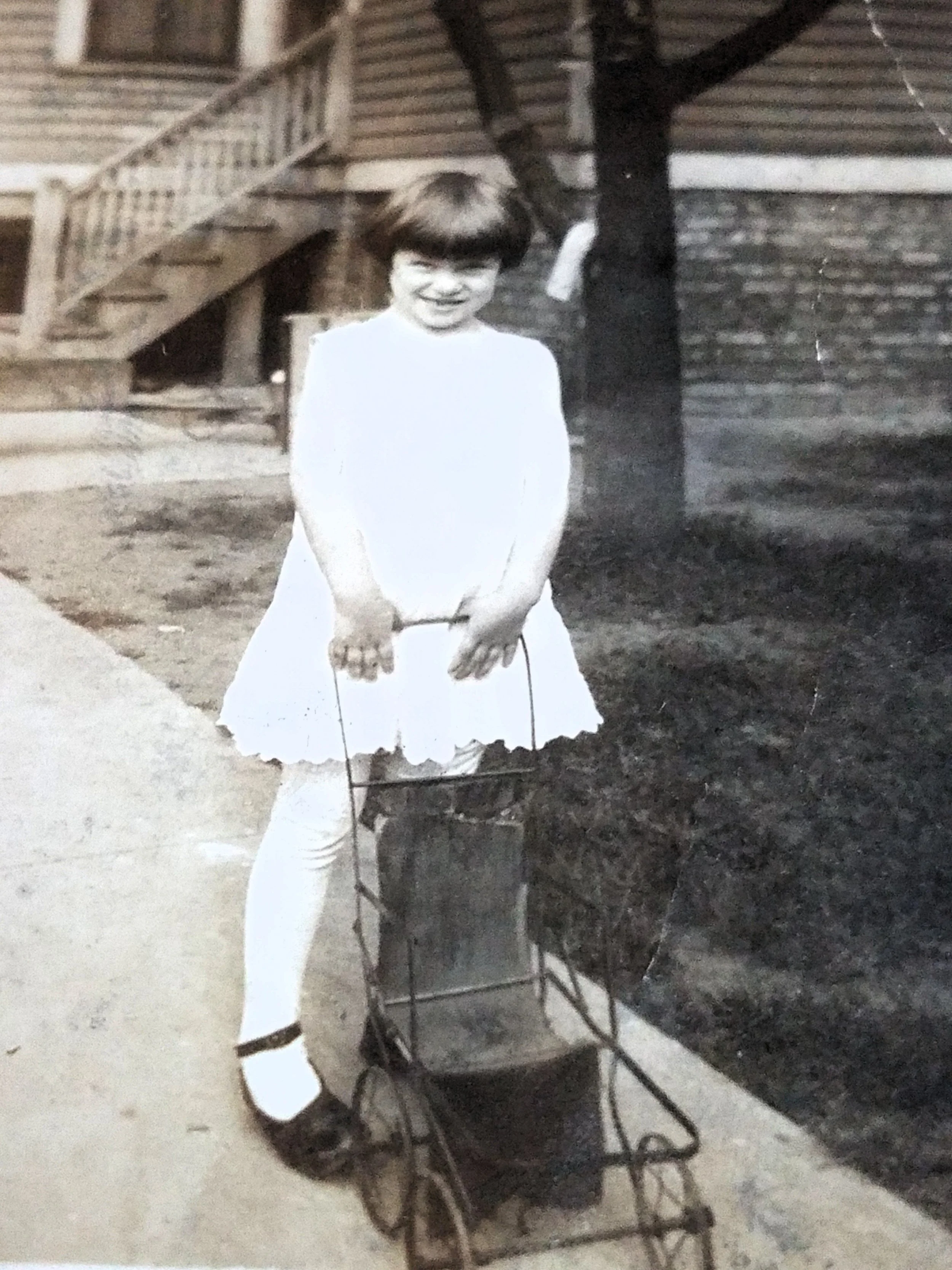 Margaret Kenny as a small girl with a doll carriage outside 4875 North Ashland Avenue