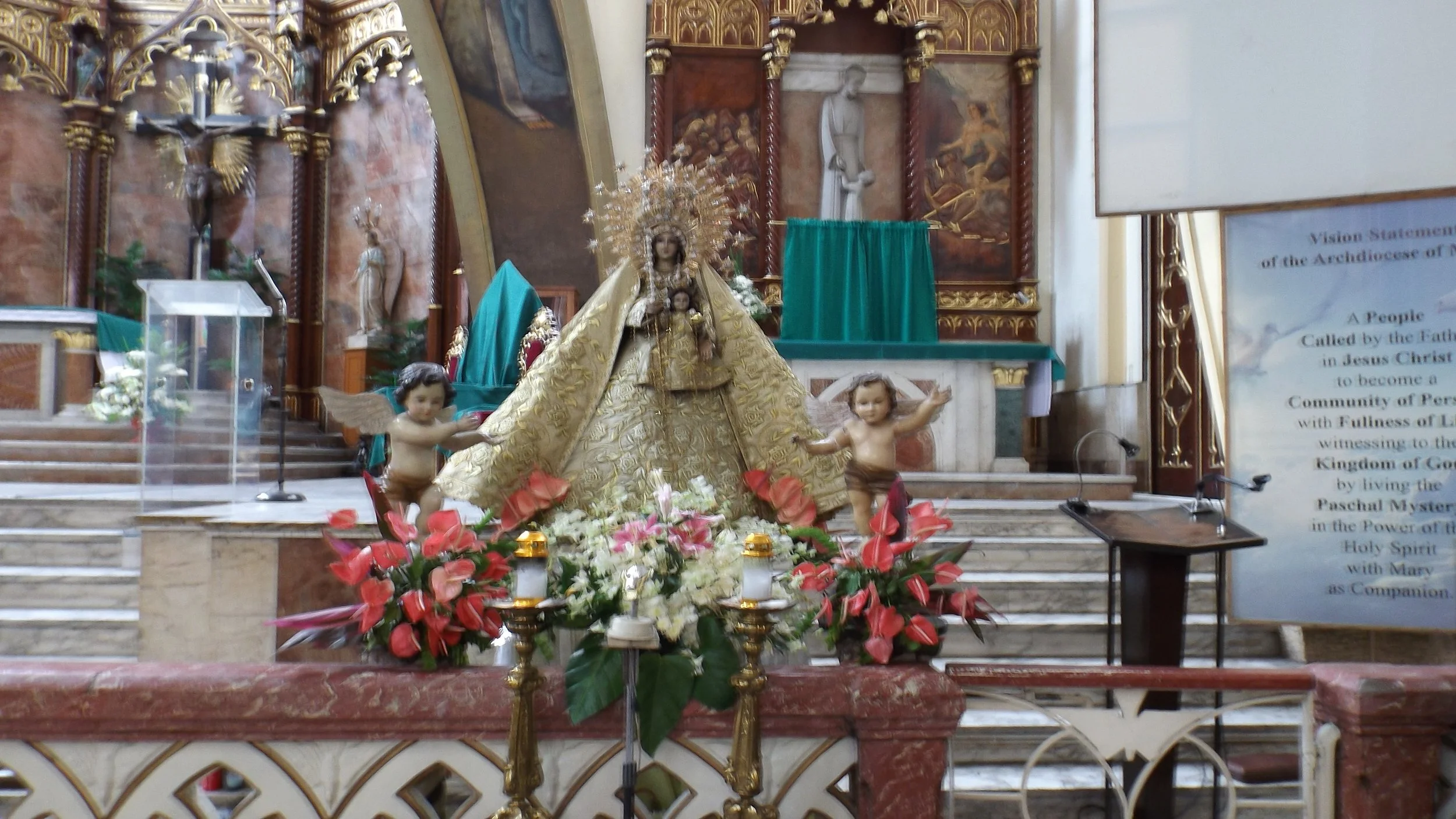 Crowned image of the Blessed Virgin Mary at Espiritu Santo Parish, flanked by angels and flowers