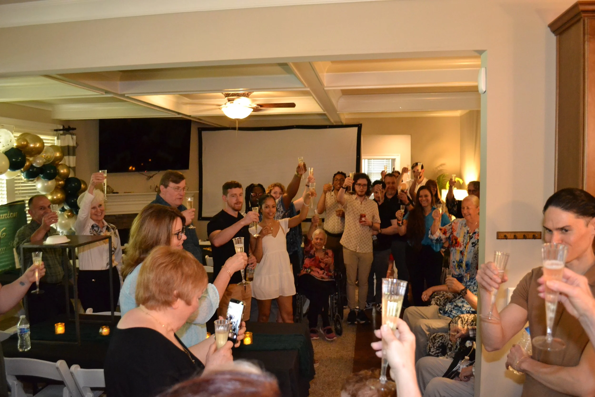 The family raising champagne flutes in toast to the twins