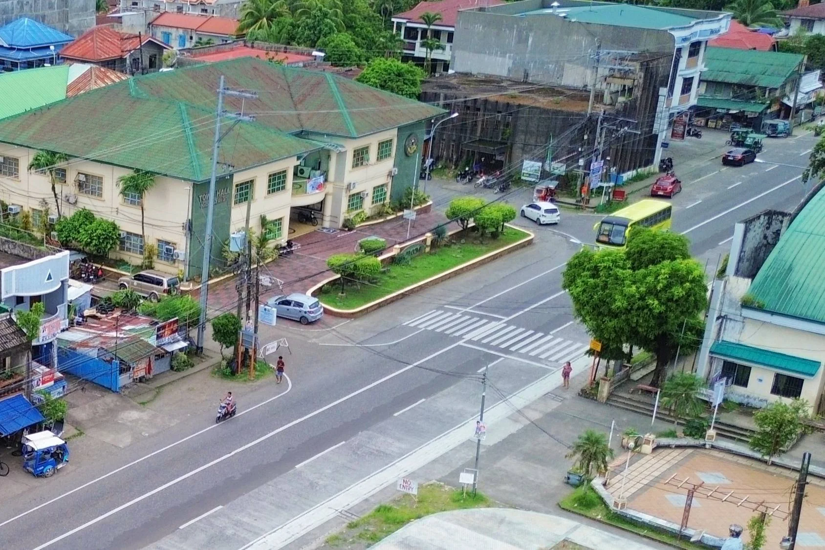 A street-level view of Numancia's town center, with the municipal hall, shops, and tricycles