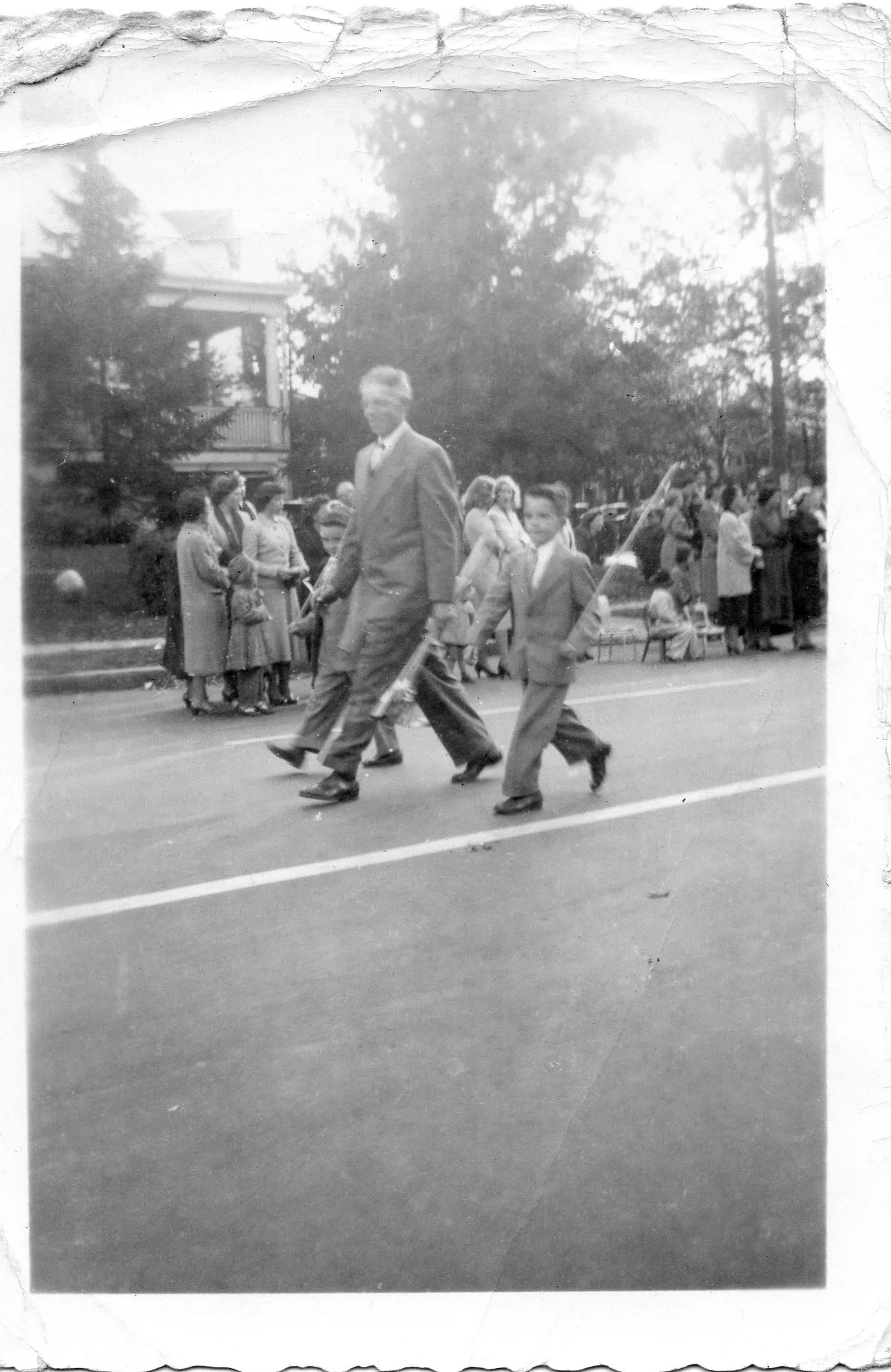 One of the twins marching with Grandpa in a parade, about age 8-10