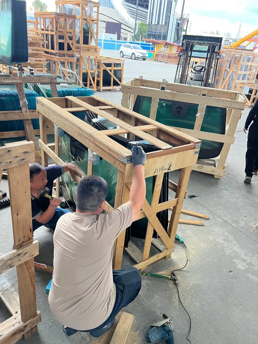 Workers reinforcing a wooden crate for automotive glass