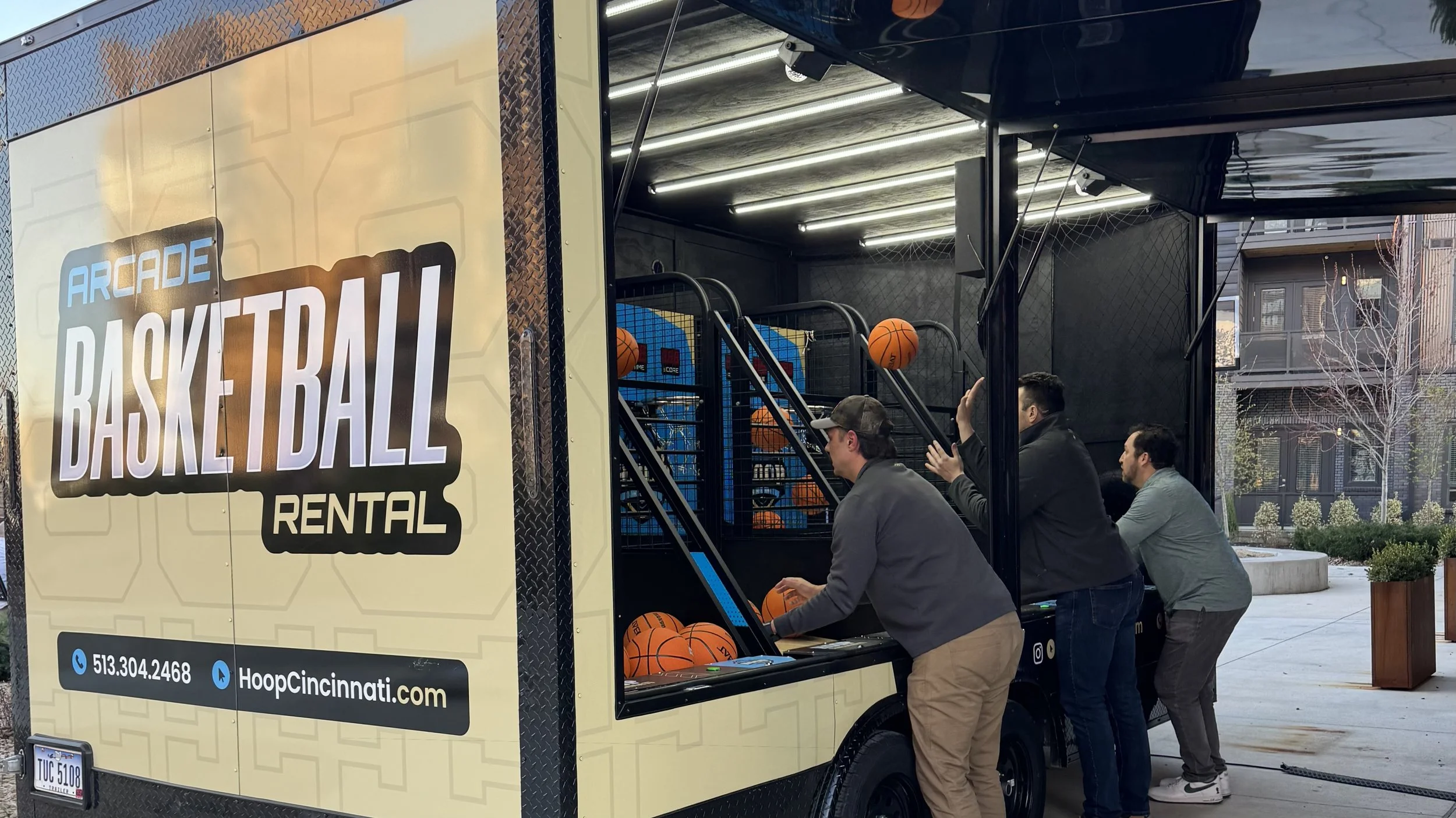 Three men playing basketball arcade at corporate event