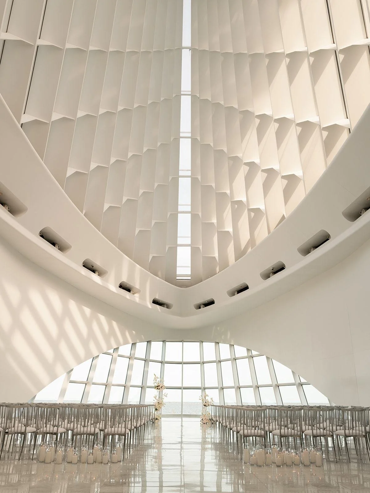 Empty ceremony seating under the white ribbed ceiling of Windhover Hall at the Milwaukee Art Museum