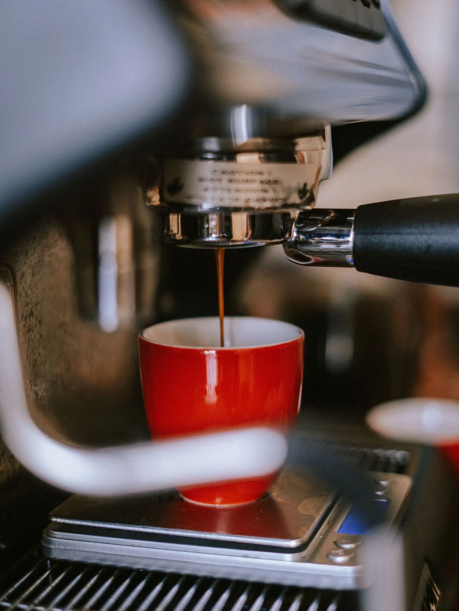 Espresso pulling into a red cup on a scale